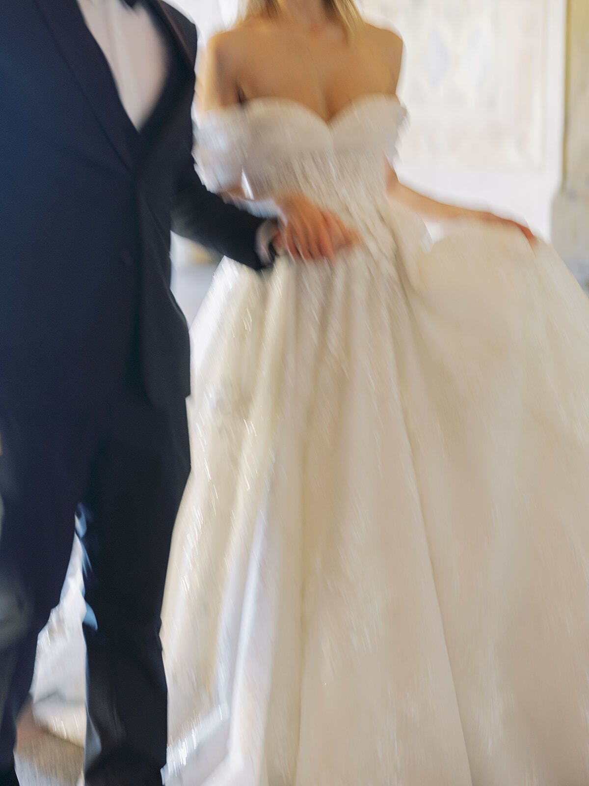 Novia con vestido de princesa de hombros descubiertos junto al novio