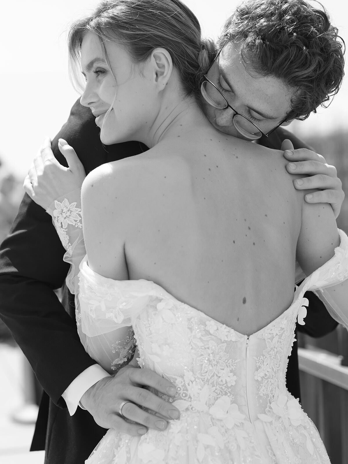 Foto en blanco y negro de un novio abrazando a la novia por detrás