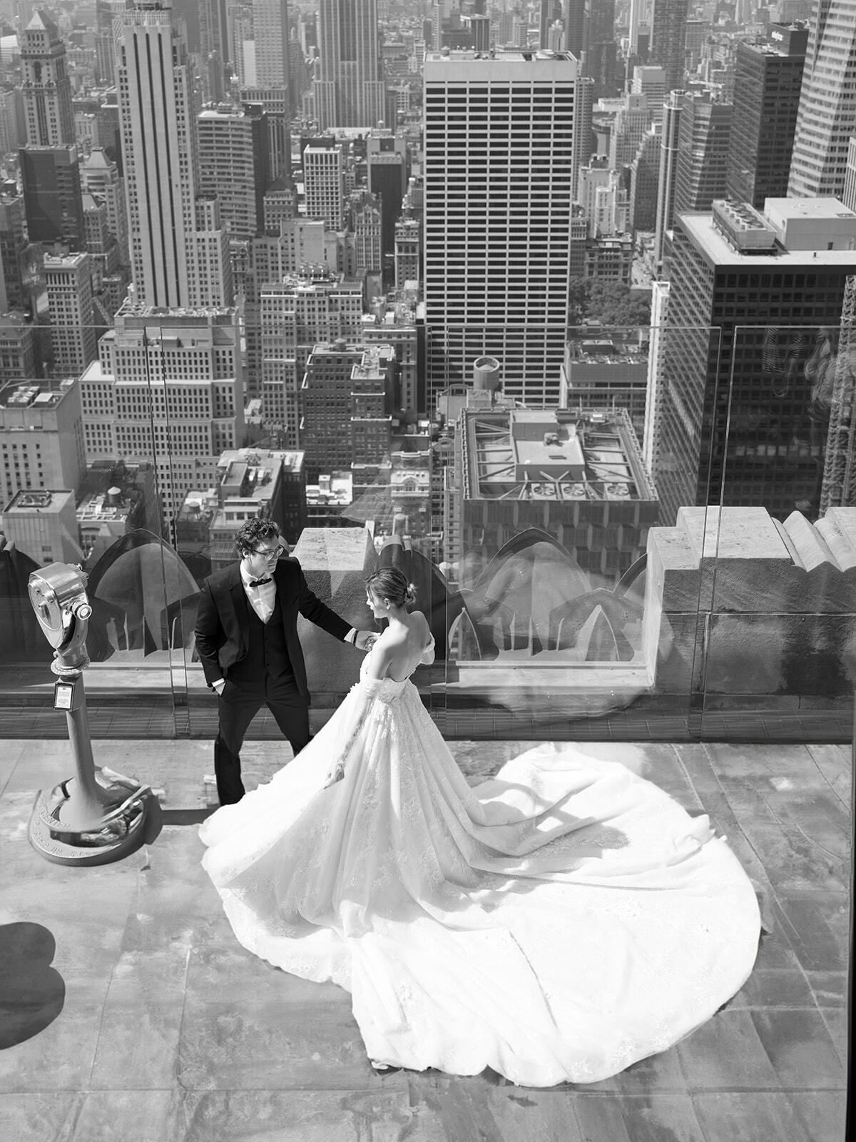 Foto en blanco y negro de una novia con larga cola en una azotea de Nueva York