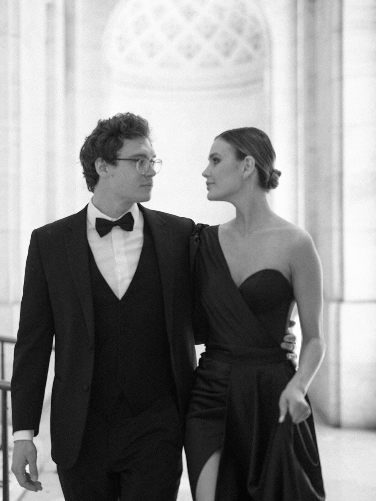 Foto en blanco y negro de una pareja de etiqueta bajo arcos de mármol, Nueva York