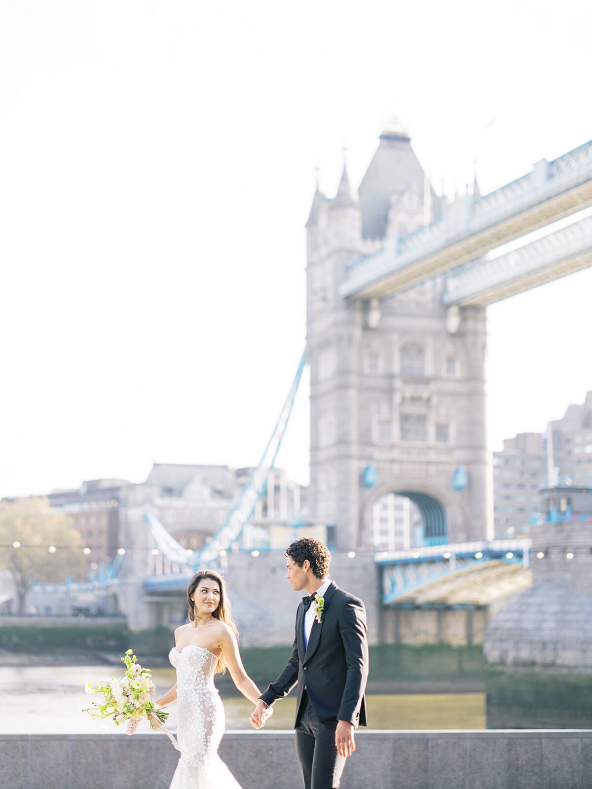 Brautpaar spaziert an der Themse, die Tower Bridge im Hintergrund