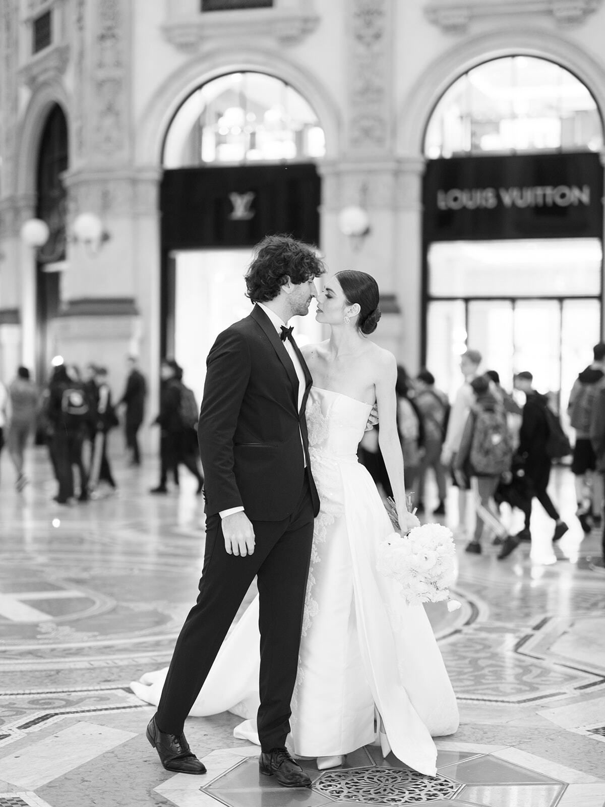 Foto en blanco y negro de una pareja en la Galería junto a Louis Vuitton