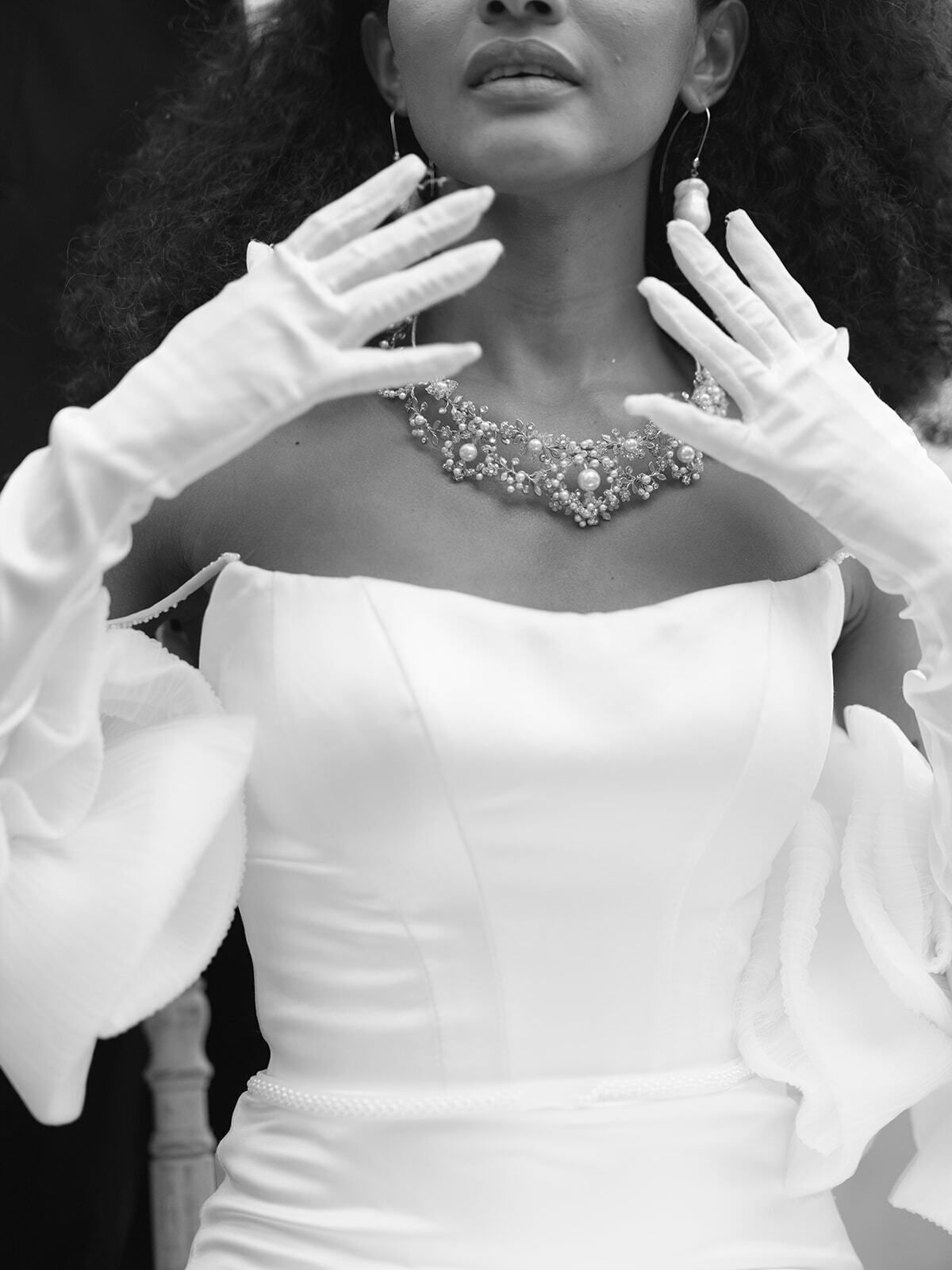 Schwarz-Weiß-Porträt einer Braut mit Handschuhen und Diamantkette