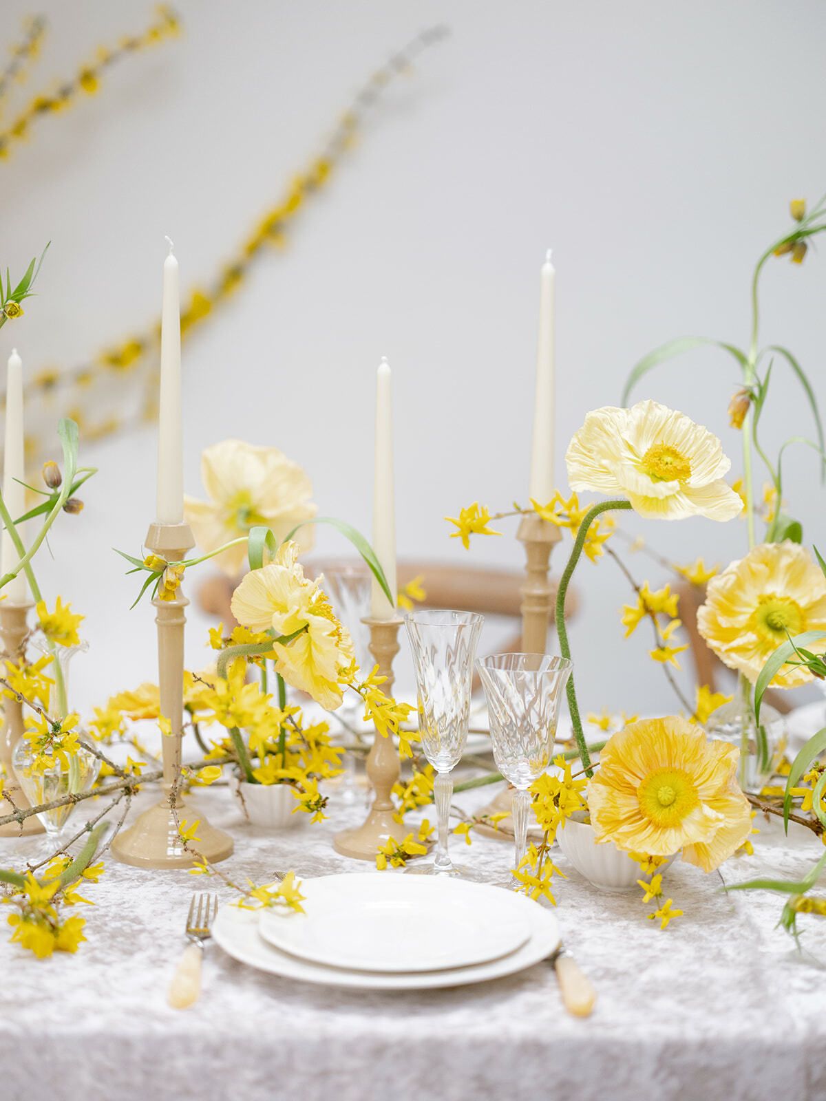Tischdekoration mit gelben Blumen und Kerzen