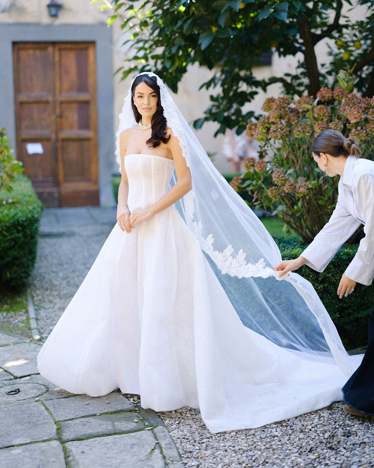 Colocando el velo de la novia en el patio de Villa Medicea di Lilliano