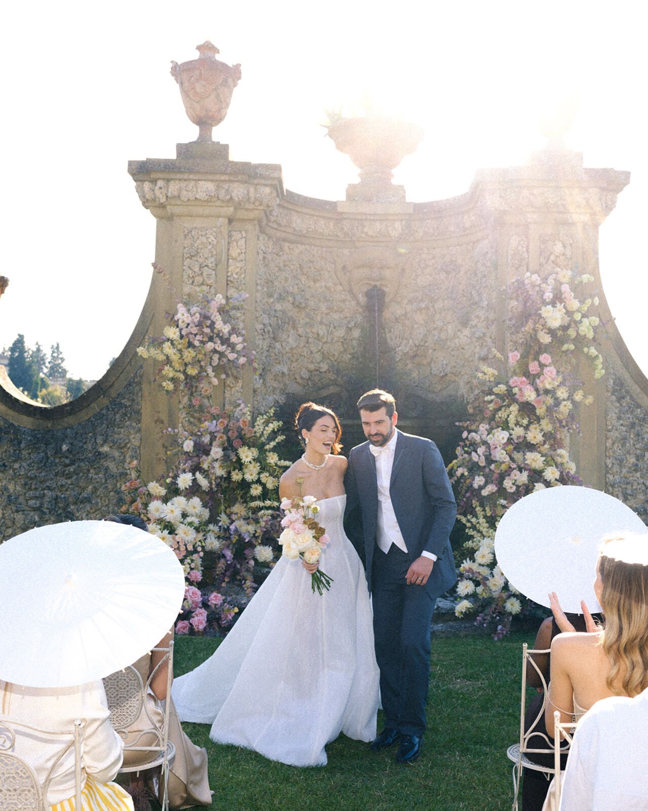 Novios en la ceremonia ante un muro barroco del jardín