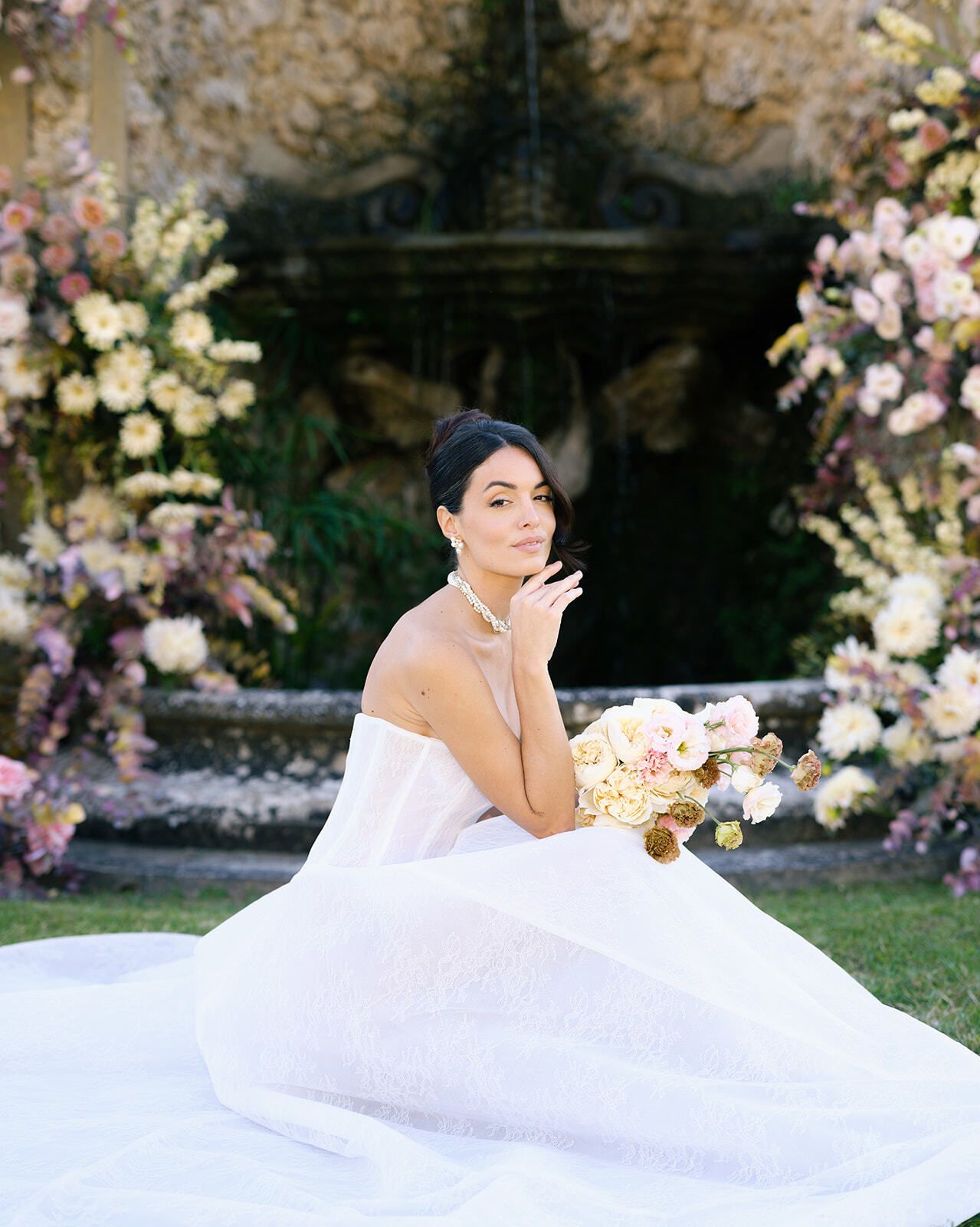 Novia sentada en el césped con un ramo, Toscana