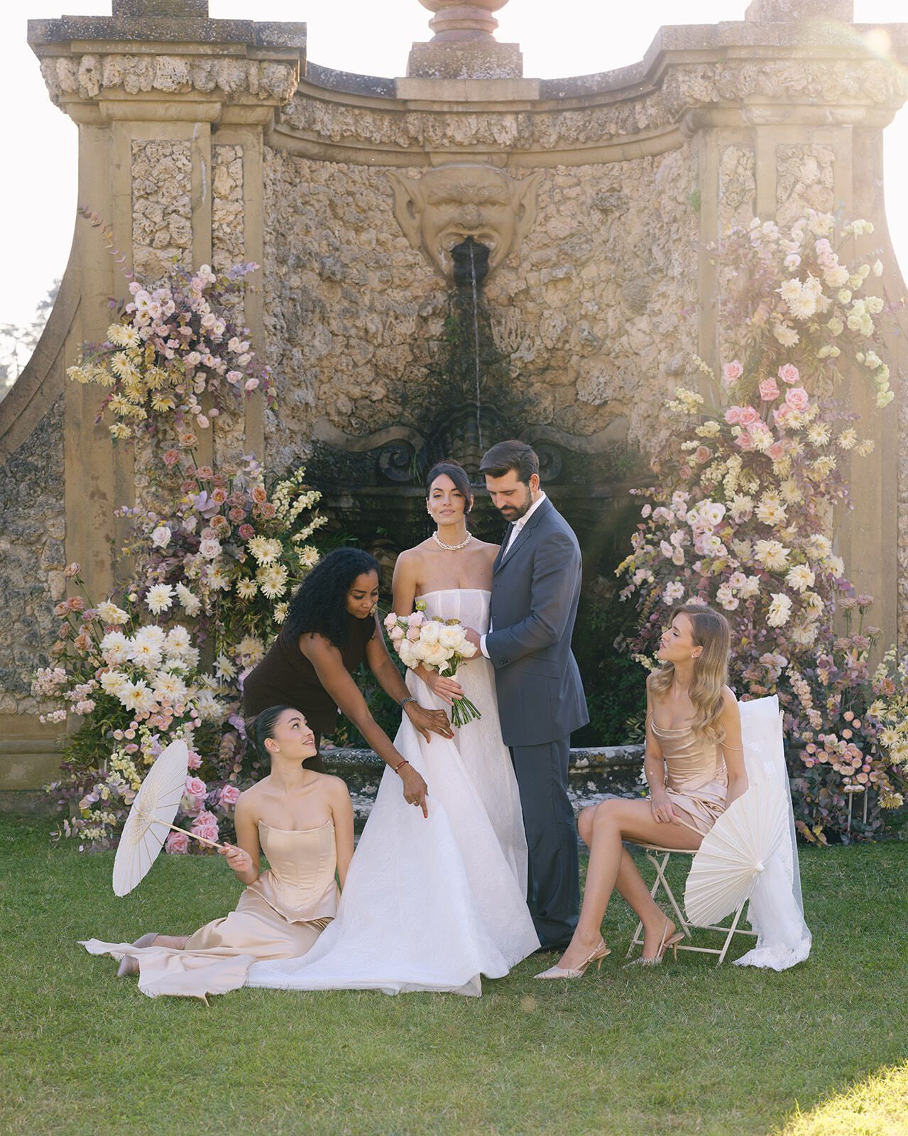 Novia, novio y damas de honor posando en el jardín
