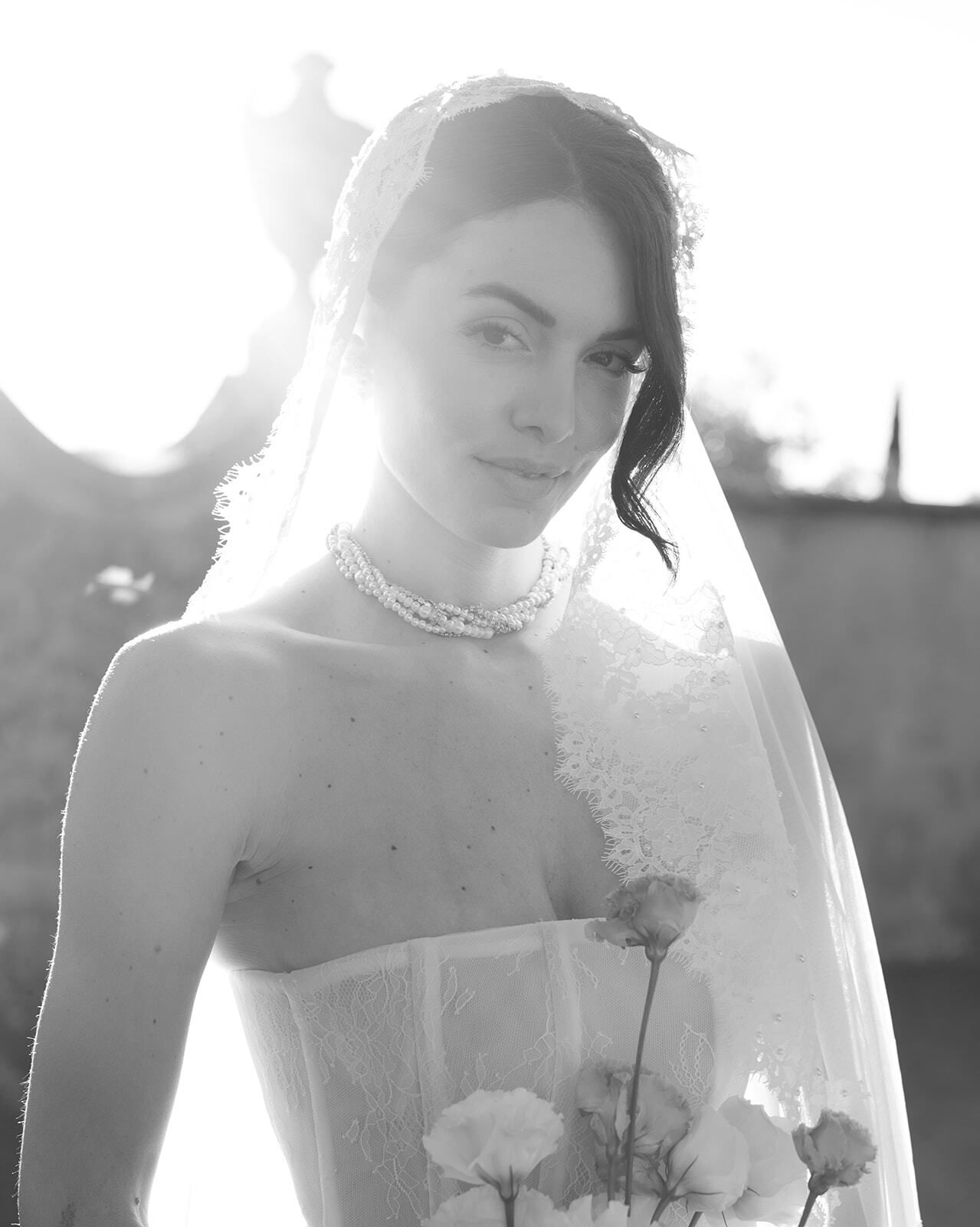 Retrato a contraluz en blanco y negro de una novia con velo