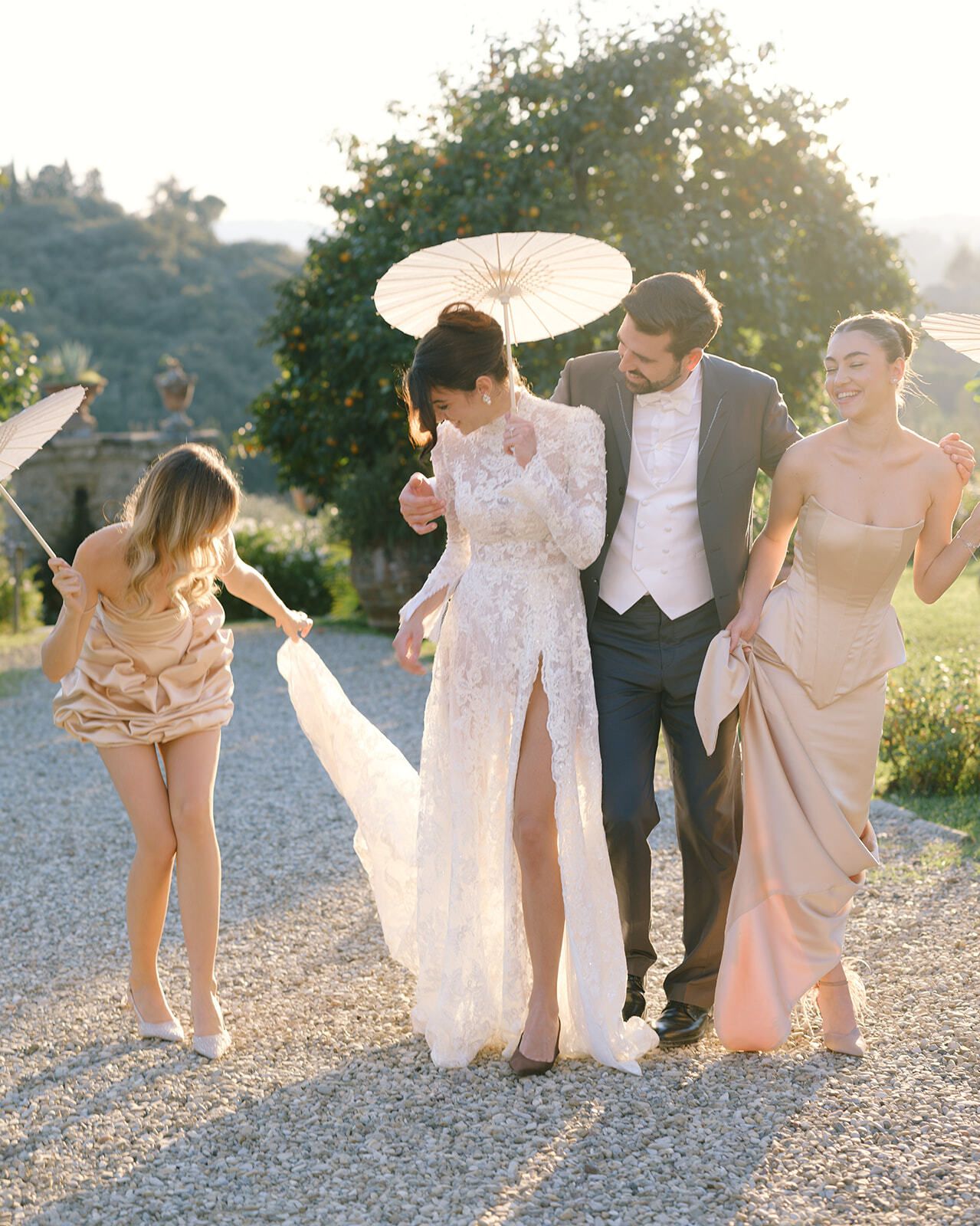 Novia, novio y damas de honor riendo al atardecer en la Toscana