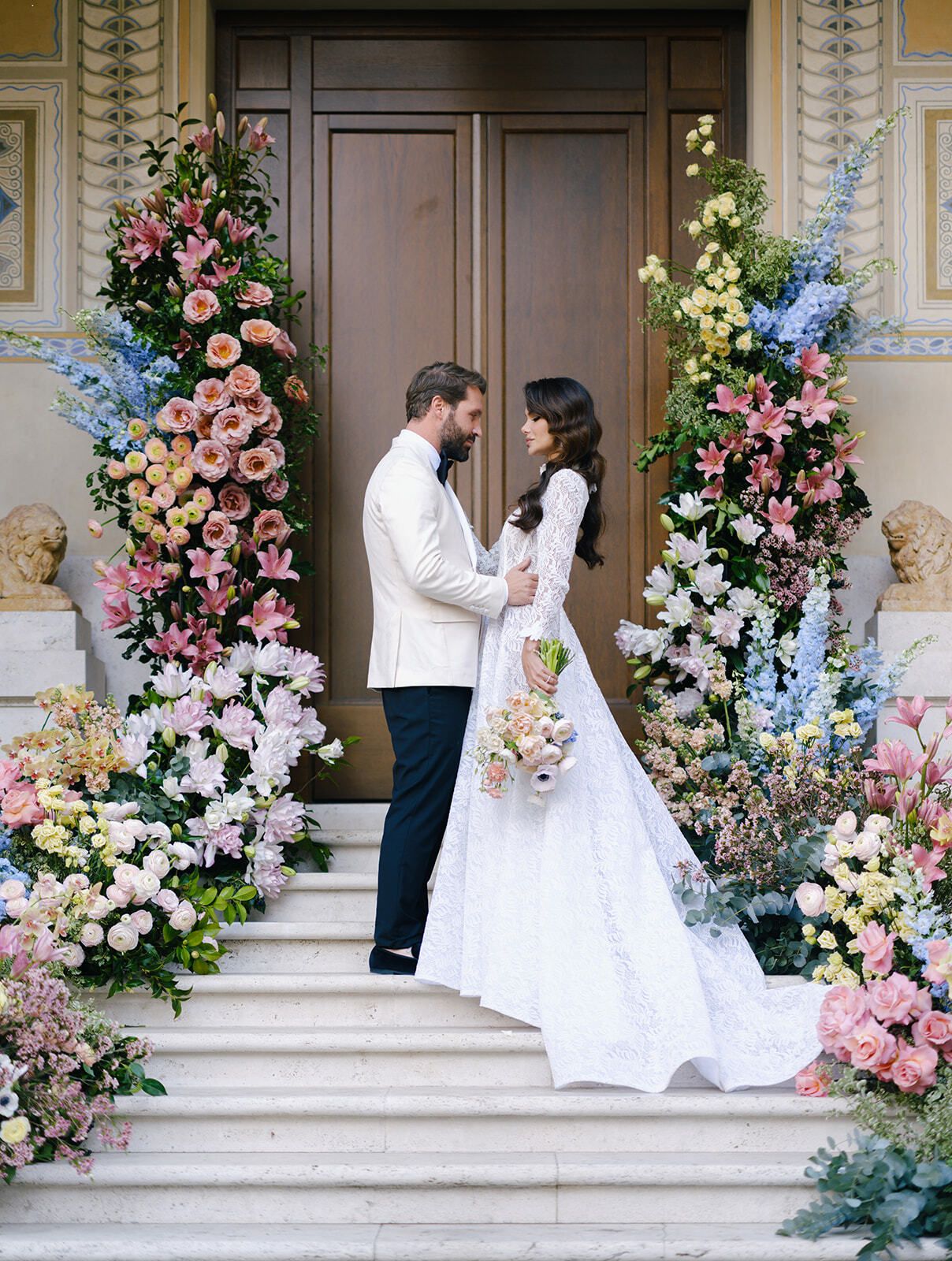 Novios en la escalinata entre columnas florales en Villa Clara