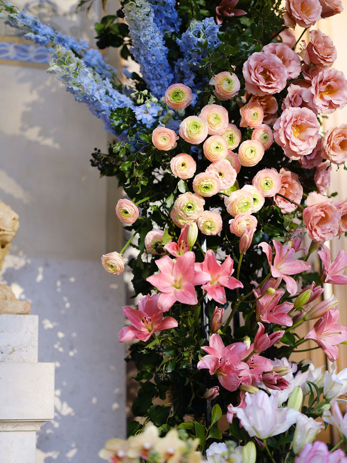 Columna floral de rosas, lirios y espuelas de caballero