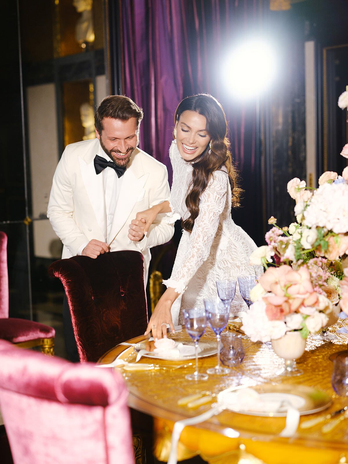 Pareja en una mesa con flores rosas y bajoplatos dorados