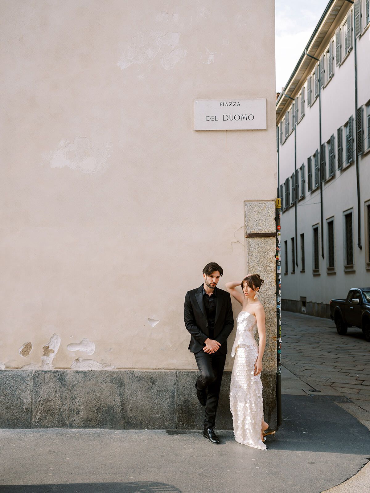 Couple leaning on a wall in a quiet Milan street
