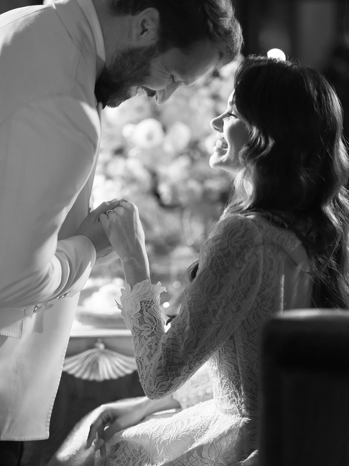 Foto en blanco y negro del novio besando la mano de la novia