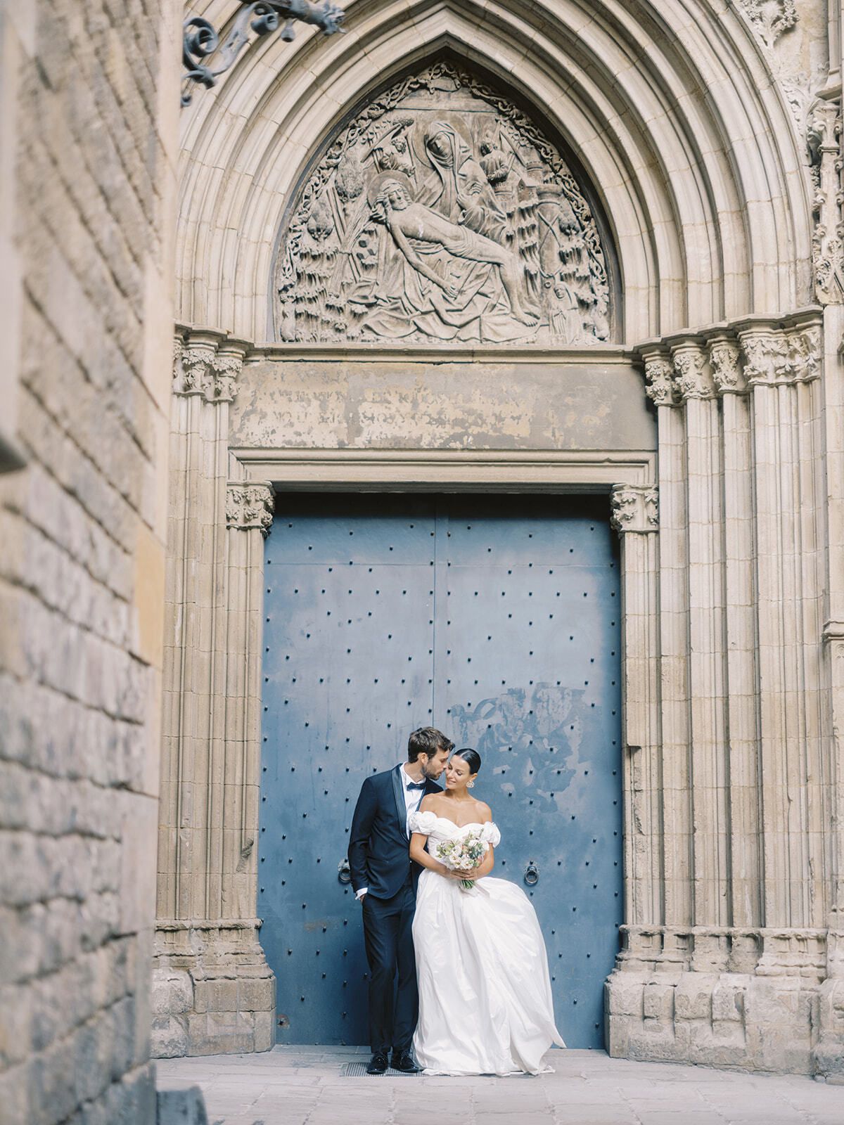 Pareja ante una puerta gótica azul en Barcelona