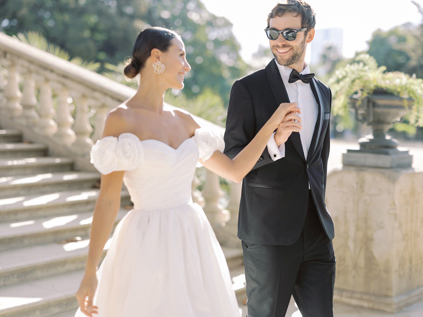 Novios riendo en una escalinata de piedra en Barcelona