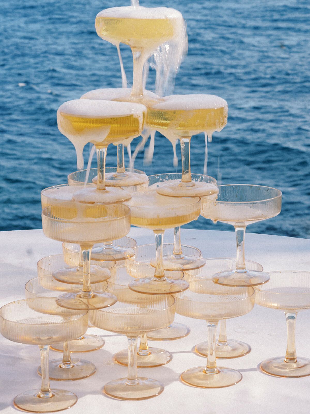Überfließender Champagnerturm vor dem blauen Mittelmeer