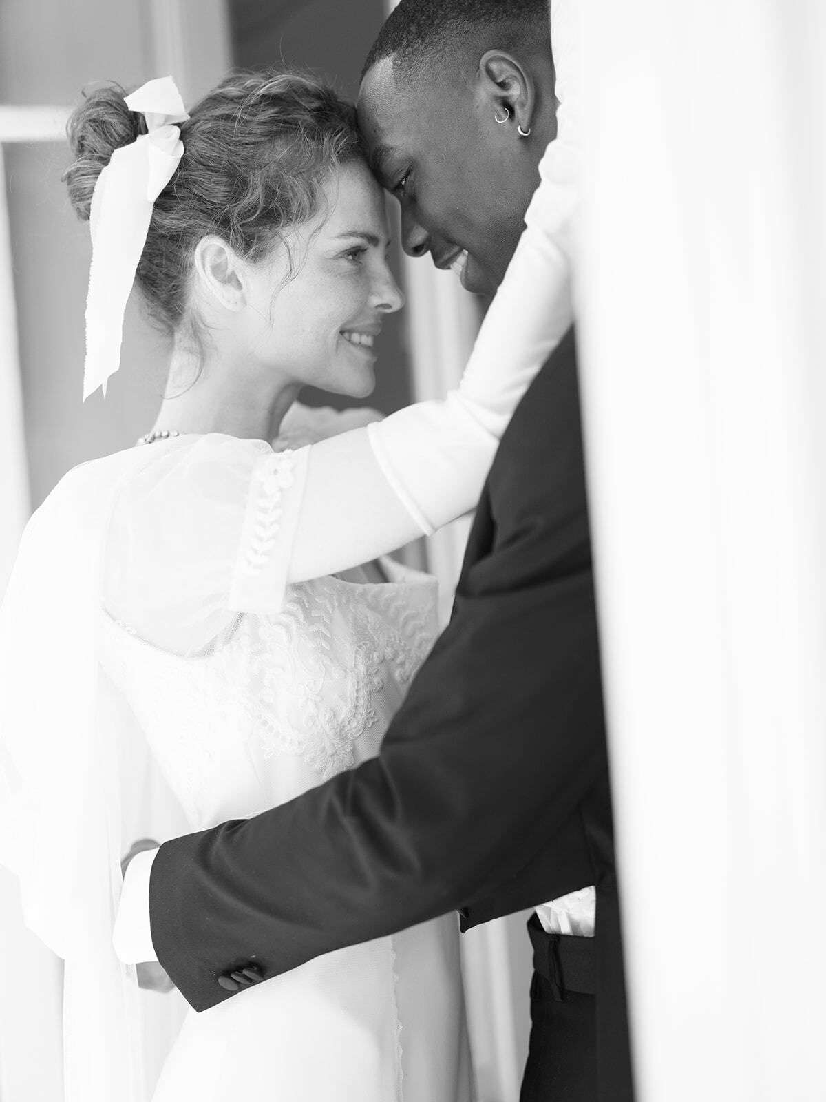 Foto en blanco y negro de los novios abrazados en una puerta
