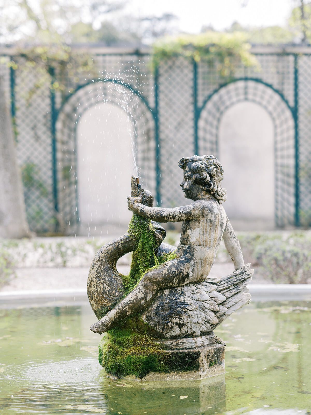 Estatua de fuente cubierta de musgo en los jardines del Château Martinay