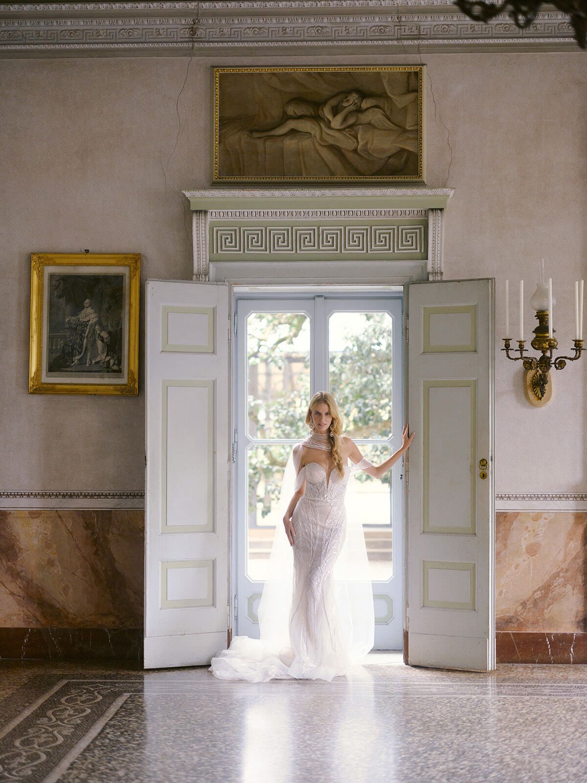 Bride in an open doorway of a frescoed villa salon