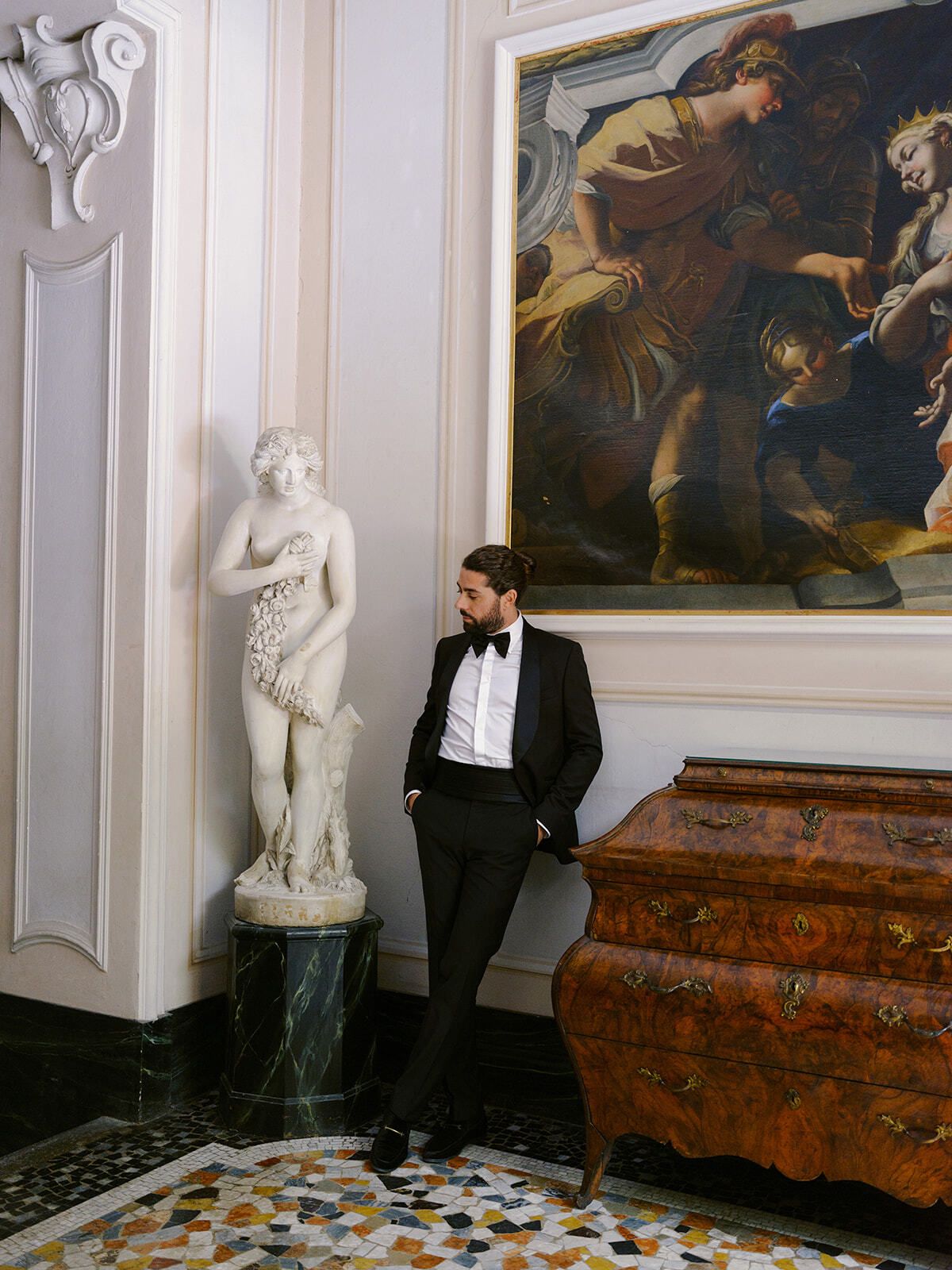 Marié près d’une statue en marbre et d’un meuble ancien à la Villa Pizzo