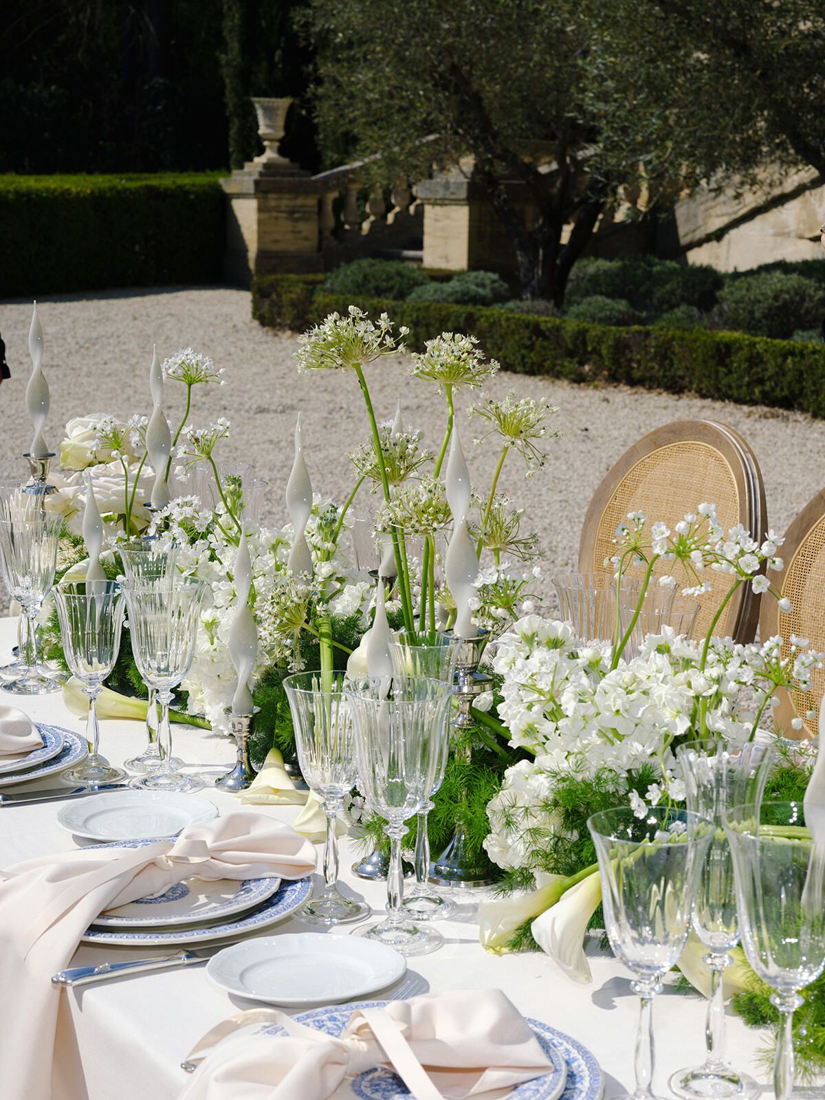 Mesa nupcial con flores blancas y sillas de mimbre en el jardín