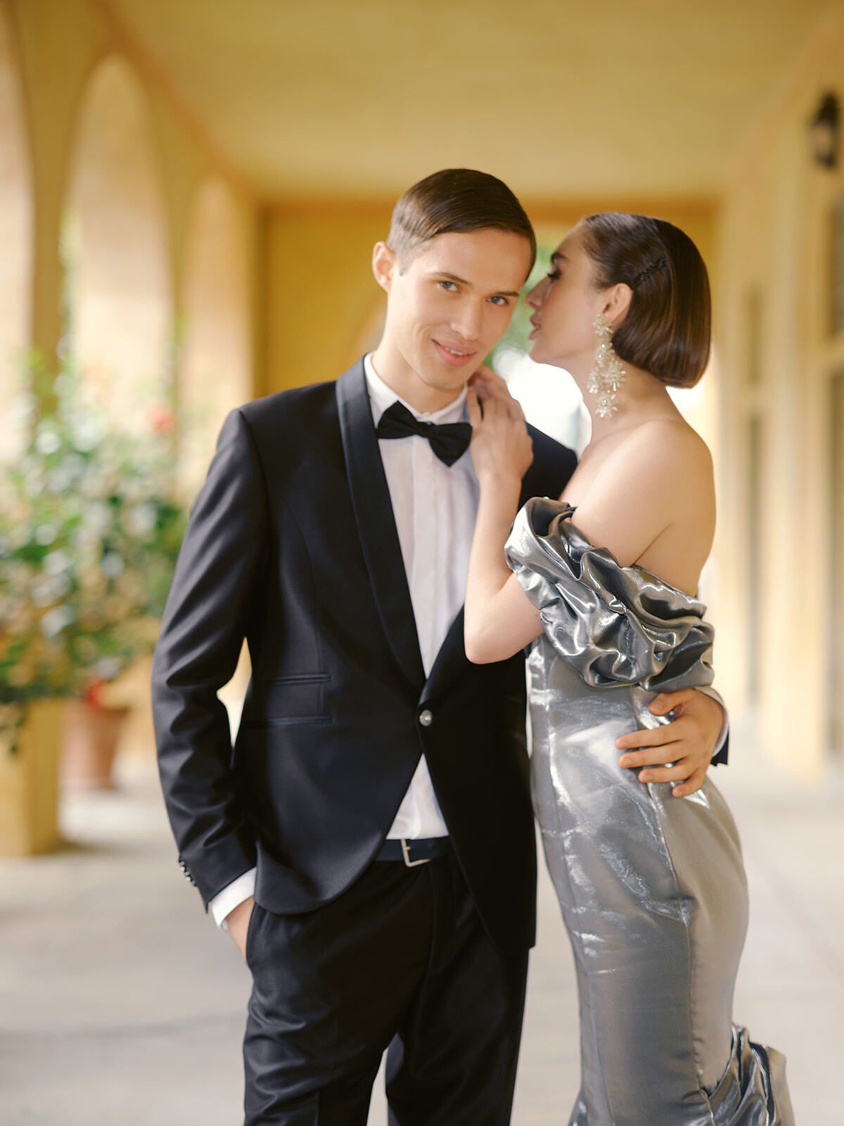 Couple en smoking et robe de satin argent dans la loggia