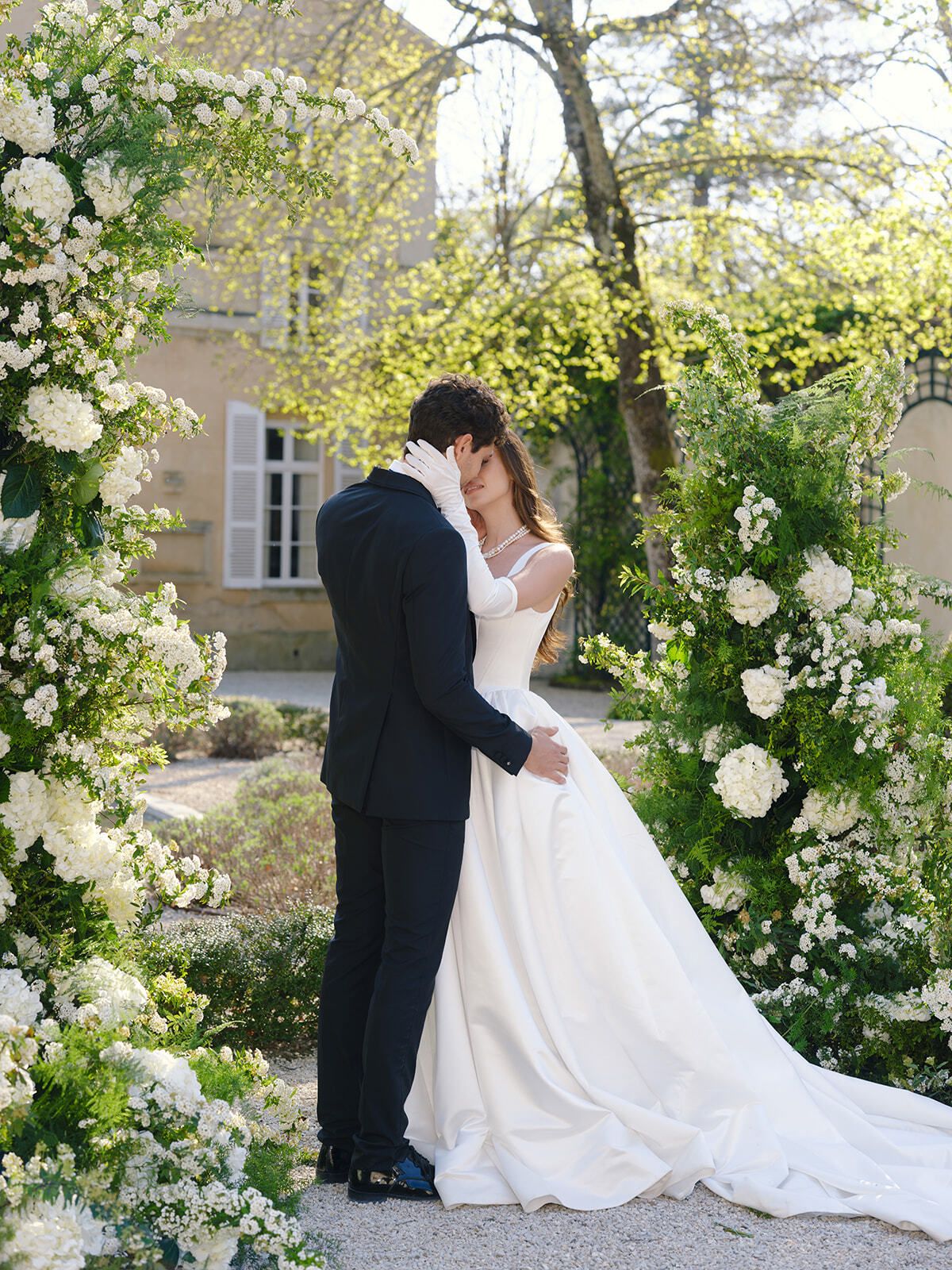 Novios bajo un arco floral blanco, Château Martinay