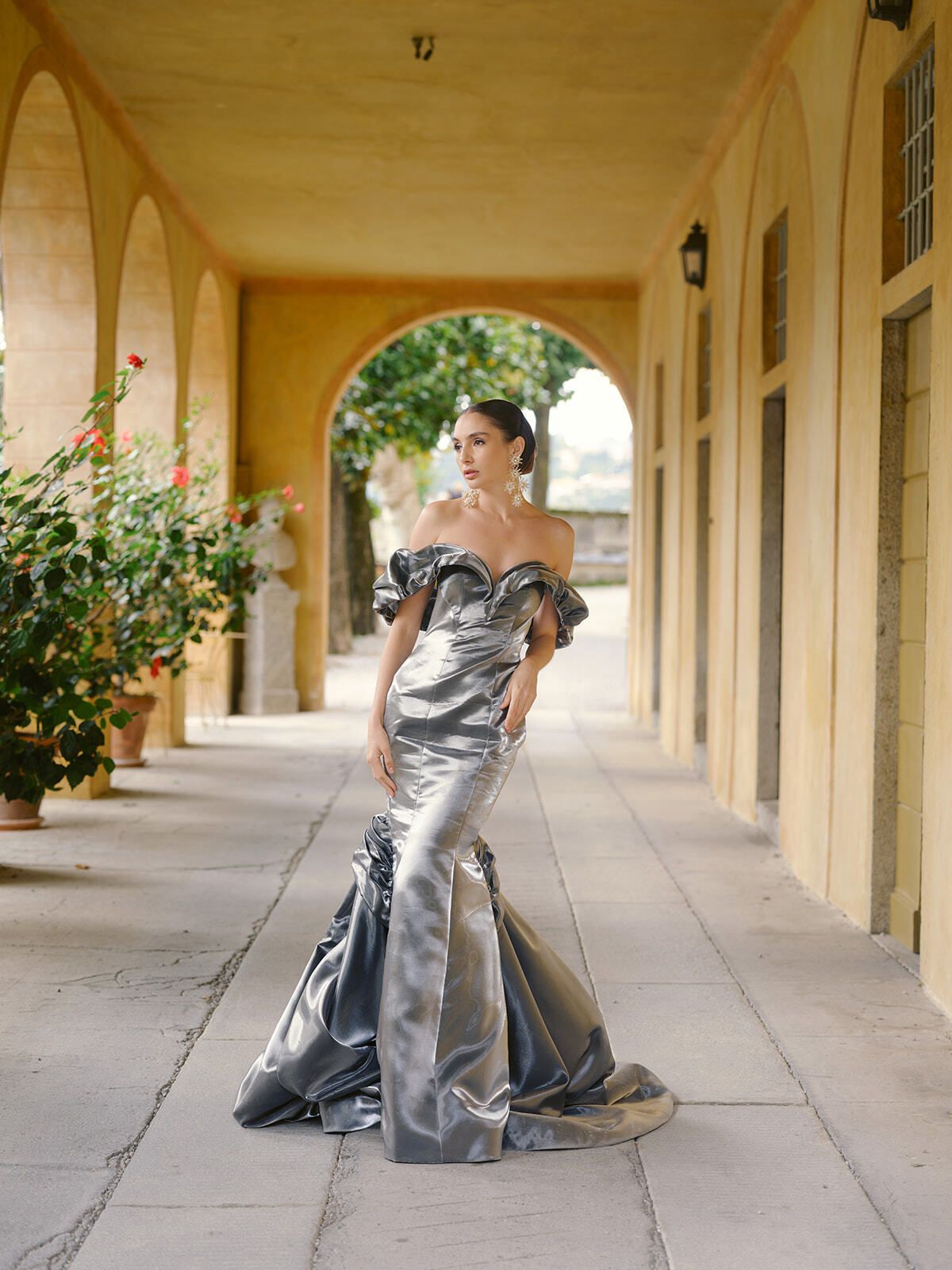 Invitée en robe sirène en satin argent dans la loggia de la Villa Pizzo