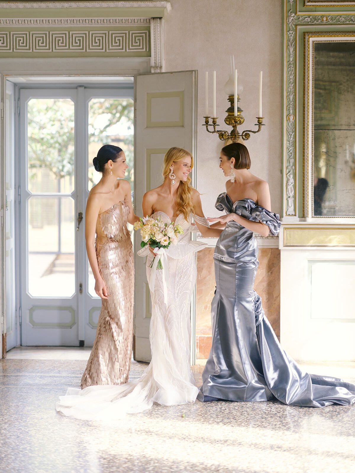 Mariée avec ses demoiselles d’honneur en robes or et argent dans un salon de la villa