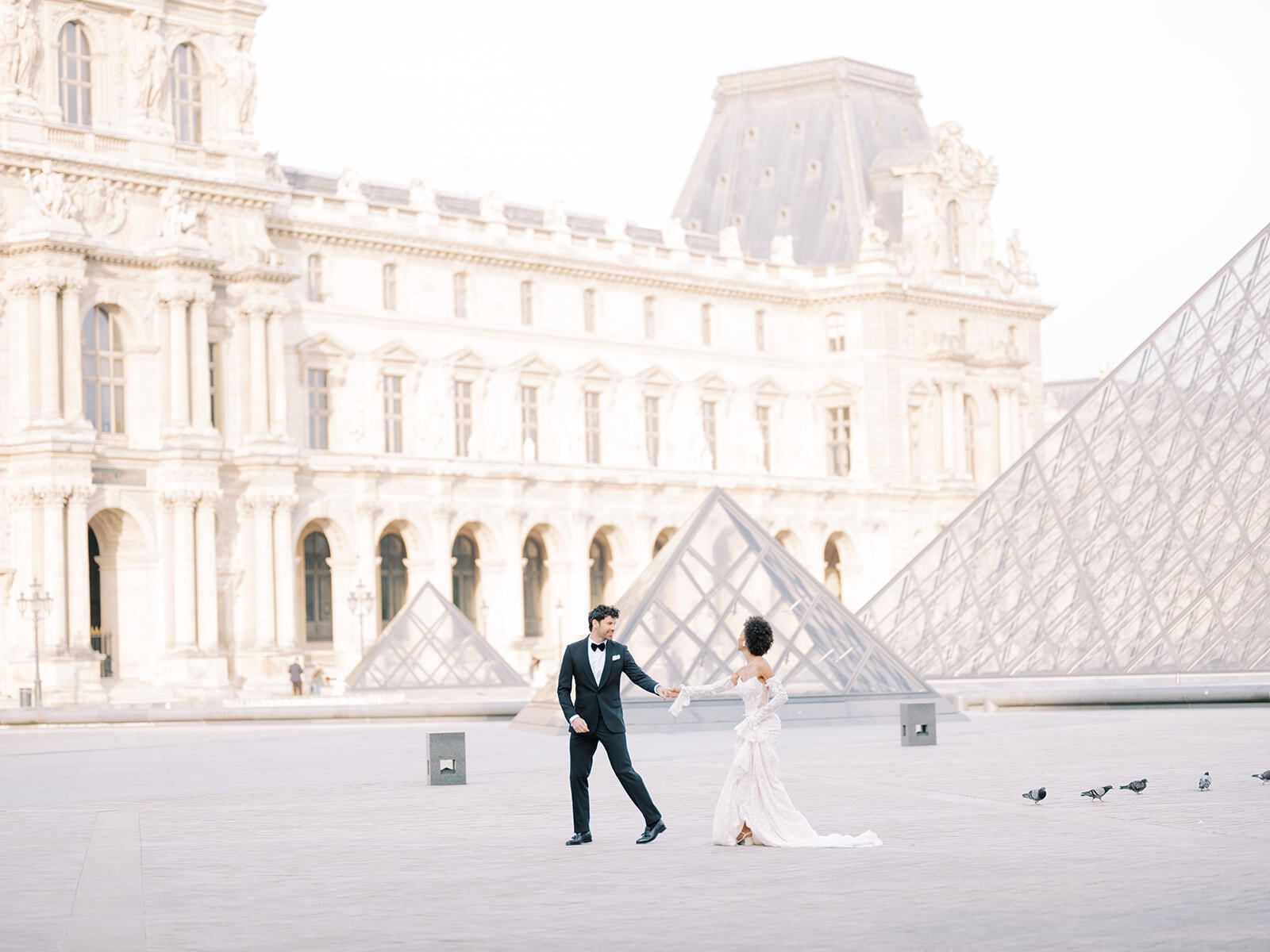 Paar überquert den Innenhof des Louvre