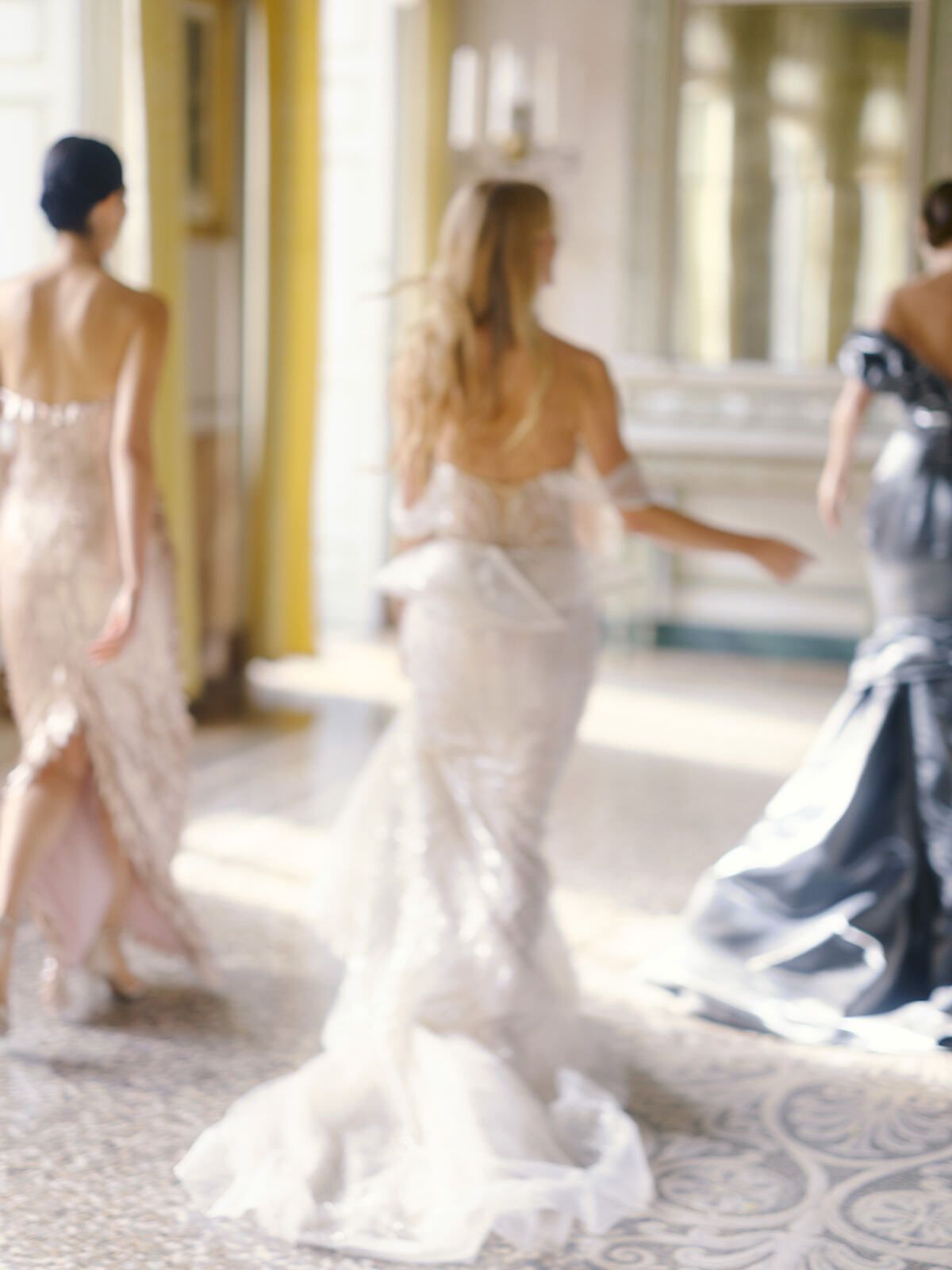 Mariée et invitées en robes chatoyantes traversant un salon