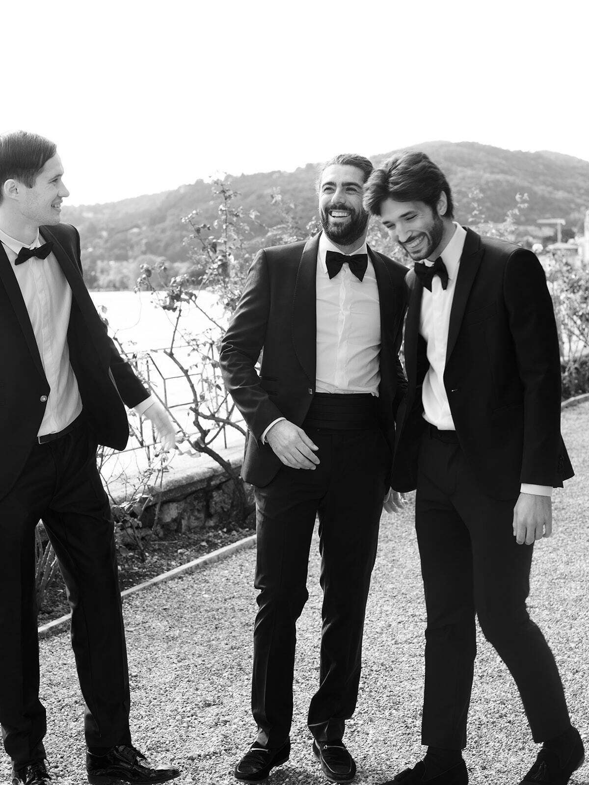 Black-and-white photo of the groom and groomsmen laughing