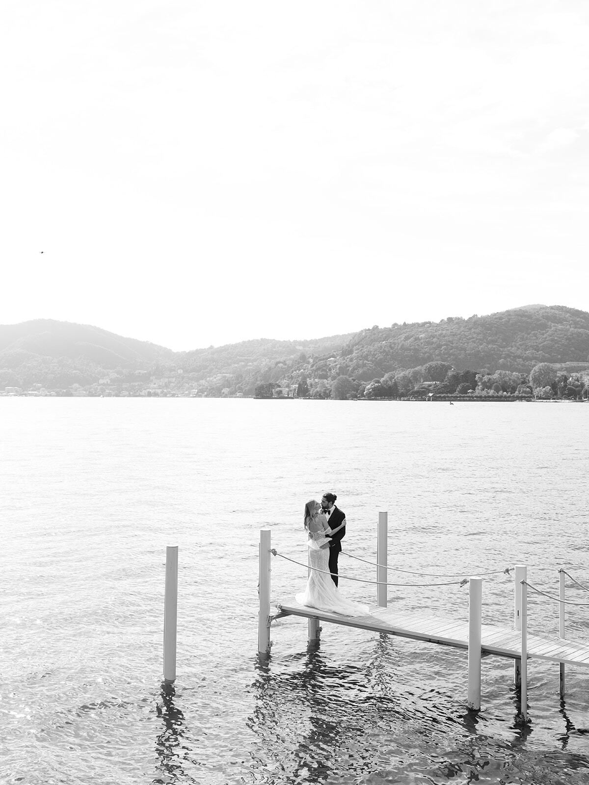 Foto en blanco y negro de la pareja al final de un embarcadero en el lago de Como
