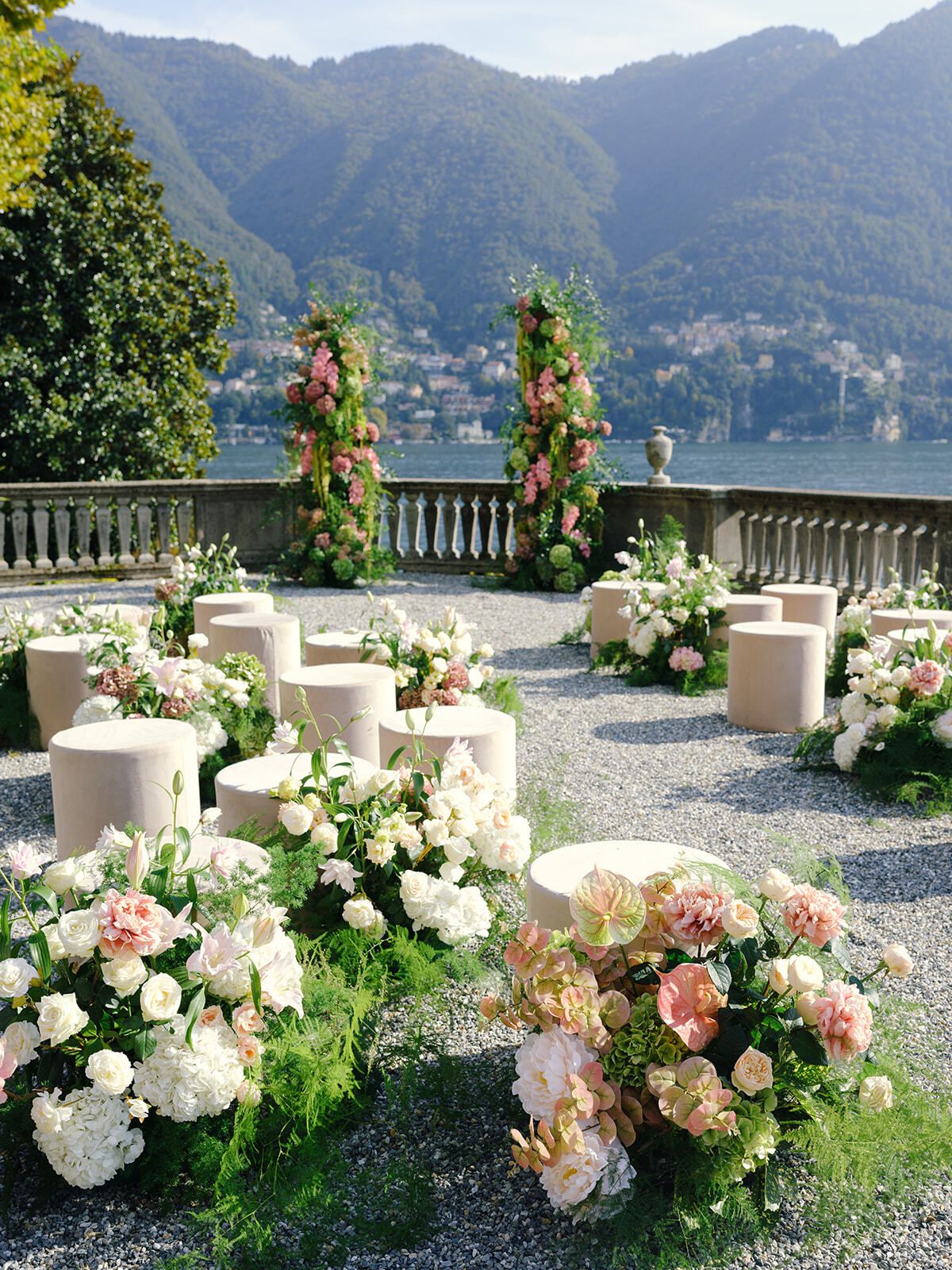 Sillas de ceremonia flanqueadas de flores en la terraza de Villa Pizzo