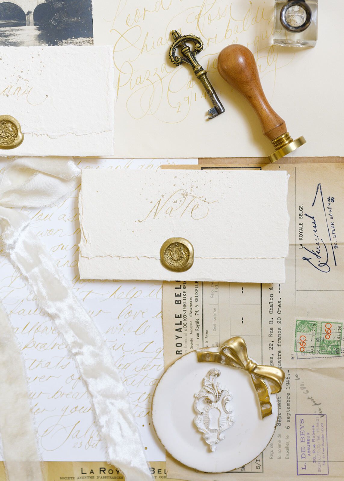 Flatlay mit Siegelstempel, antikem Schlüssel und Umschlägen