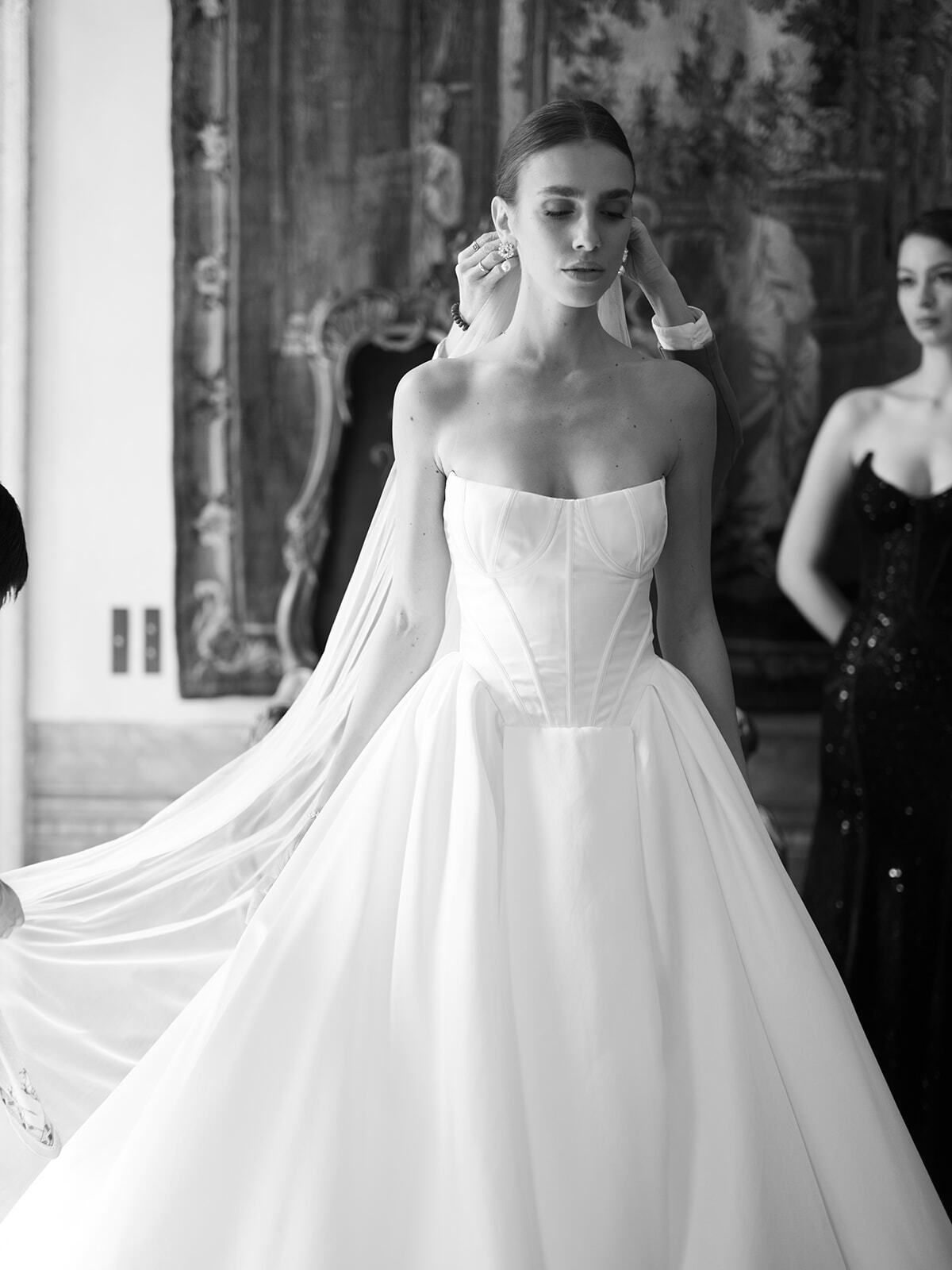 Schwarz-Weiß-Foto einer Braut in trägerlosem Kleid mit langem Schleier