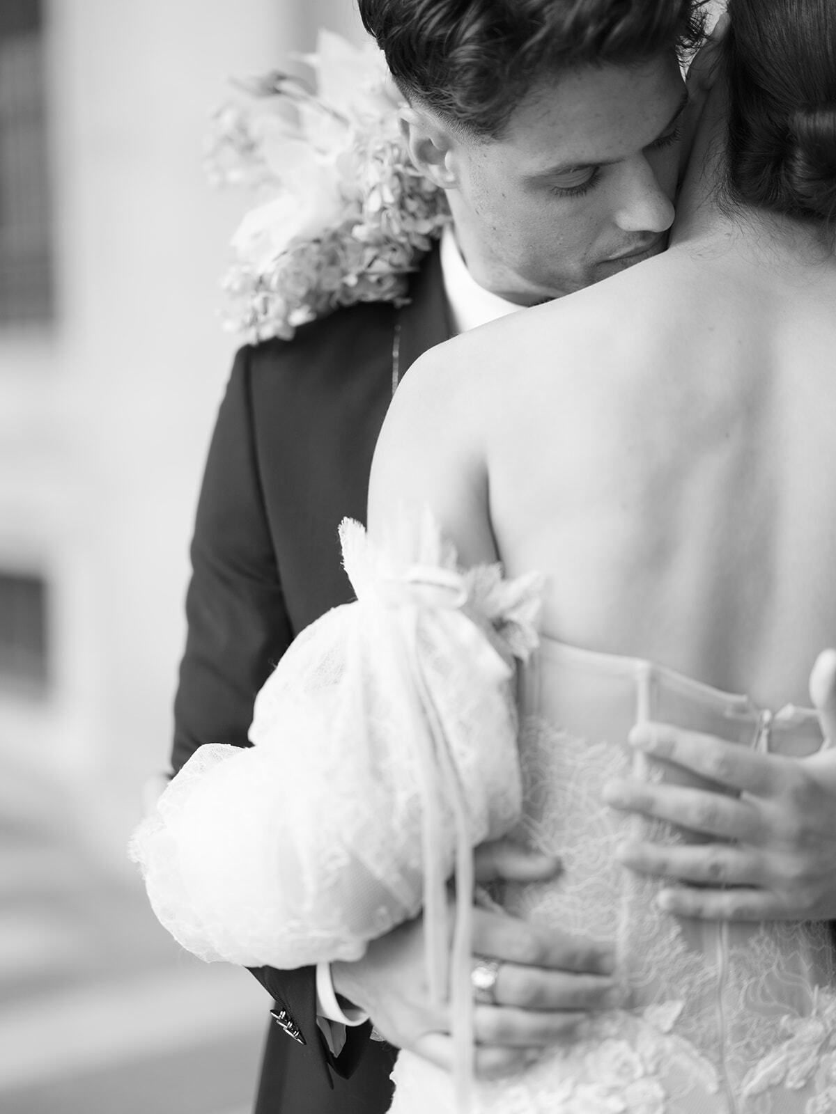 Foto en blanco y negro de un novio abrazando a la novia por detrás