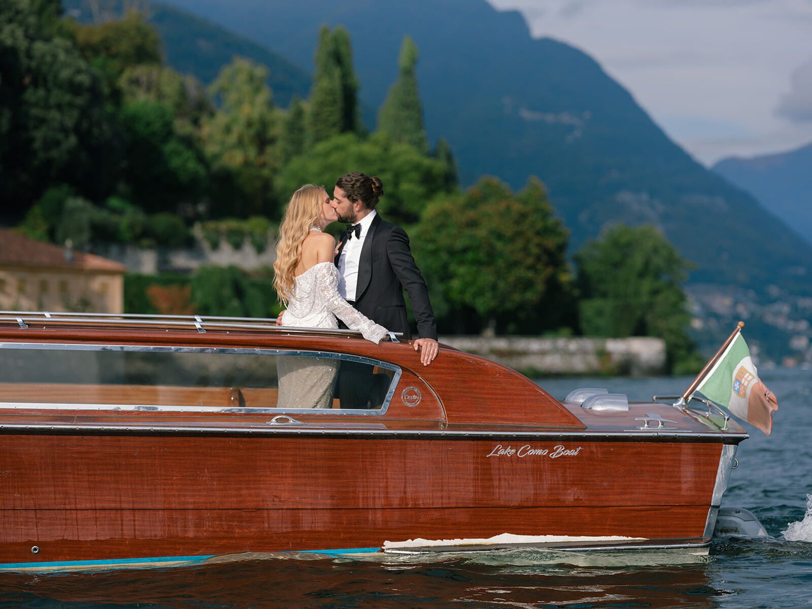 Brautpaar küsst sich auf einem klassischen Riva-Boot auf dem Comer See