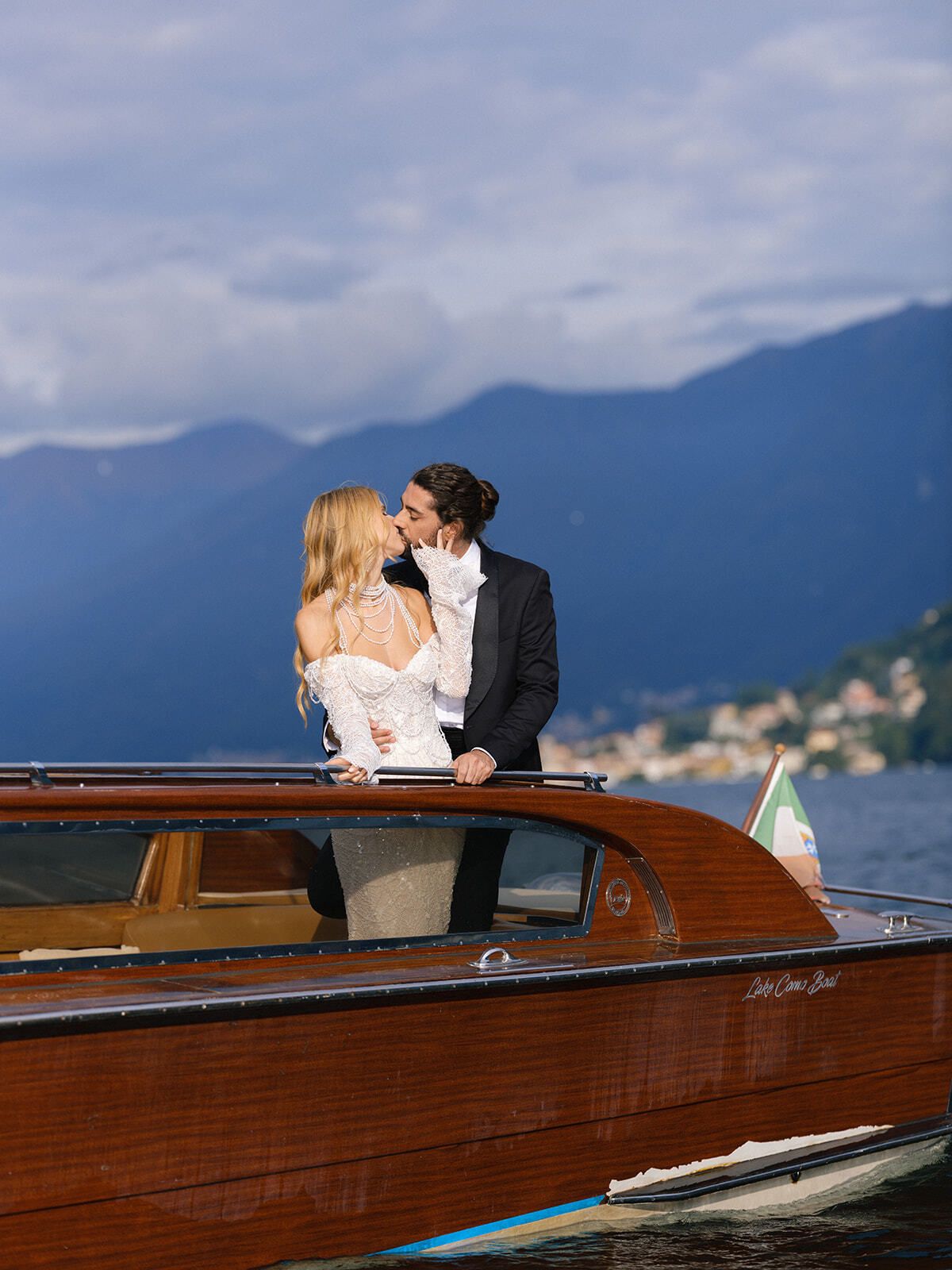 Couple standing on a wooden boat on Lake Como