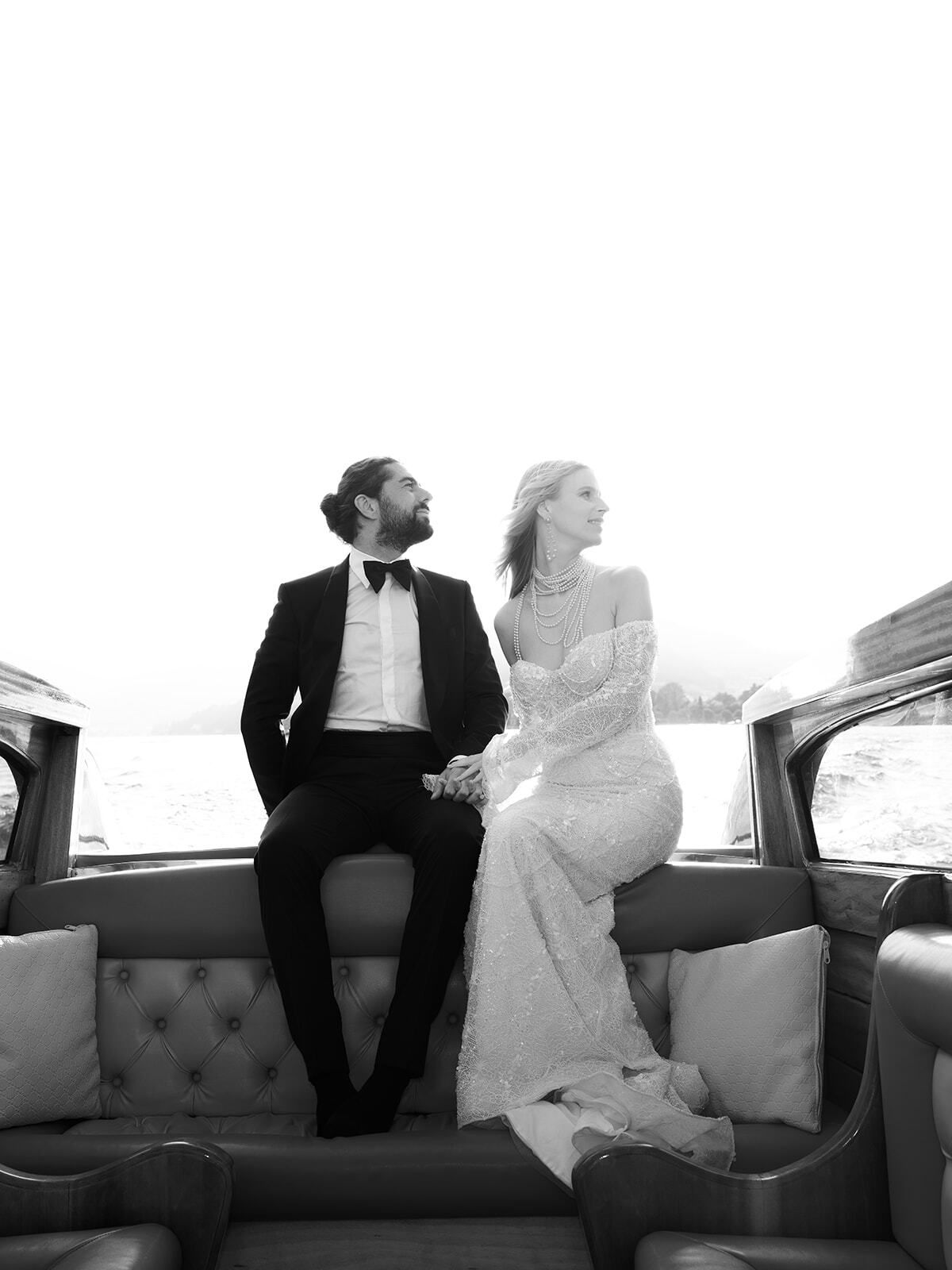 Black-and-white photo of a couple sitting on a boat's back seat