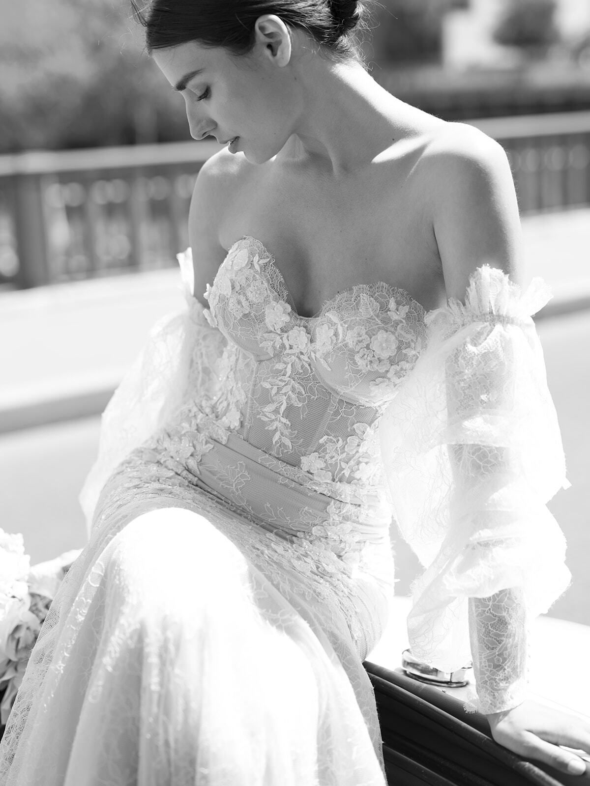 Foto en blanco y negro de una novia con vestido de encaje de hombros descubiertos