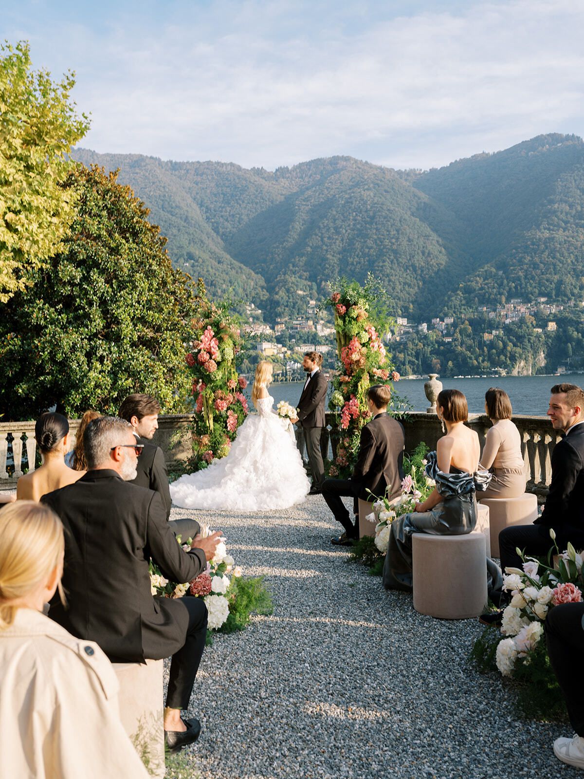 Invités regardant la mariée marcher vers la cérémonie au bord du lac