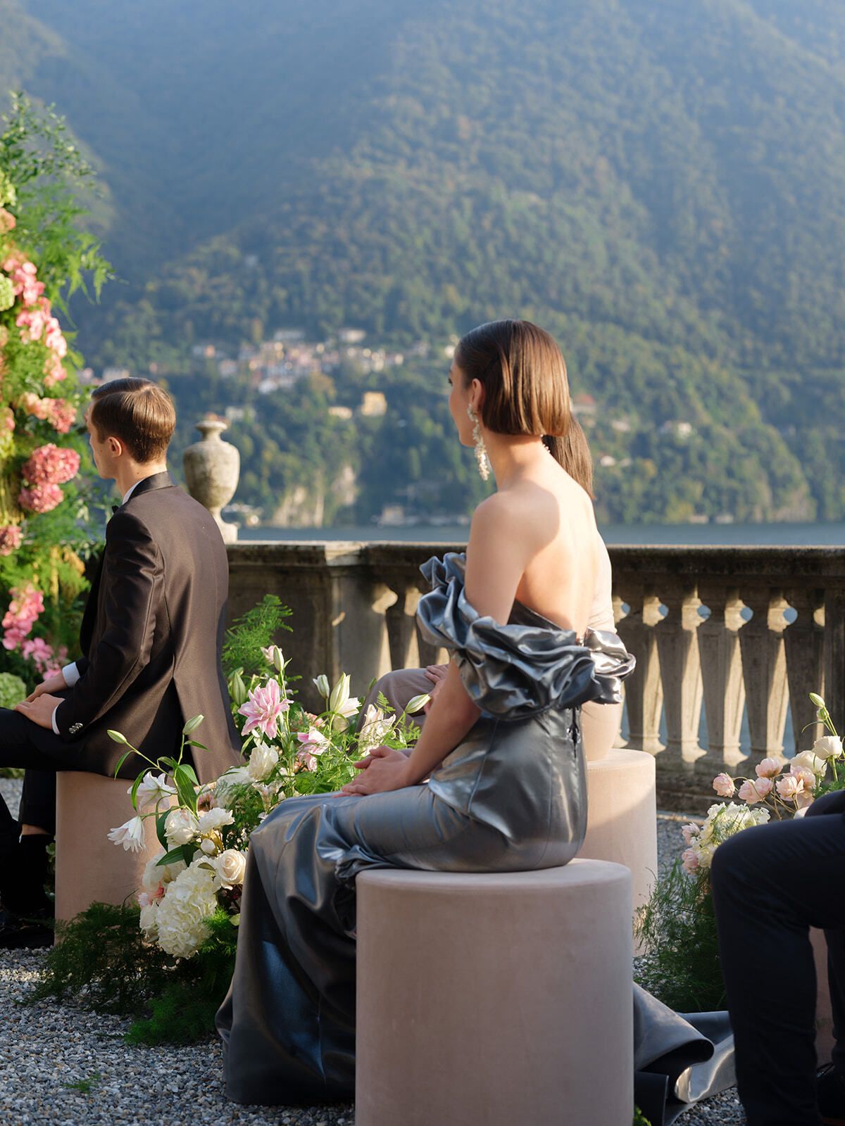 Guest in a satin gown seated at the ceremony by Lake Como