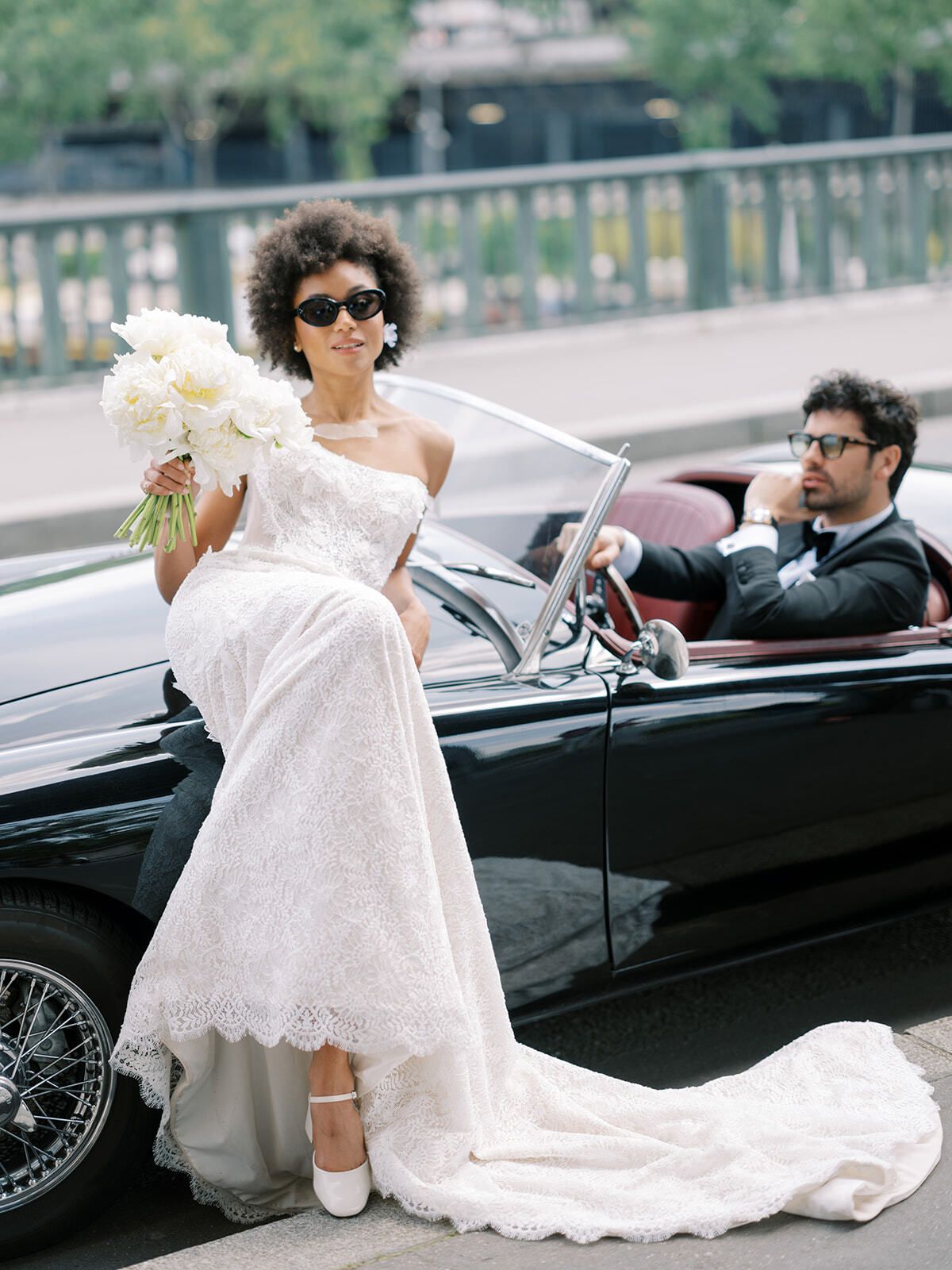 Braut mit Sonnenbrille auf einem Oldtimer-Cabrio, Paris