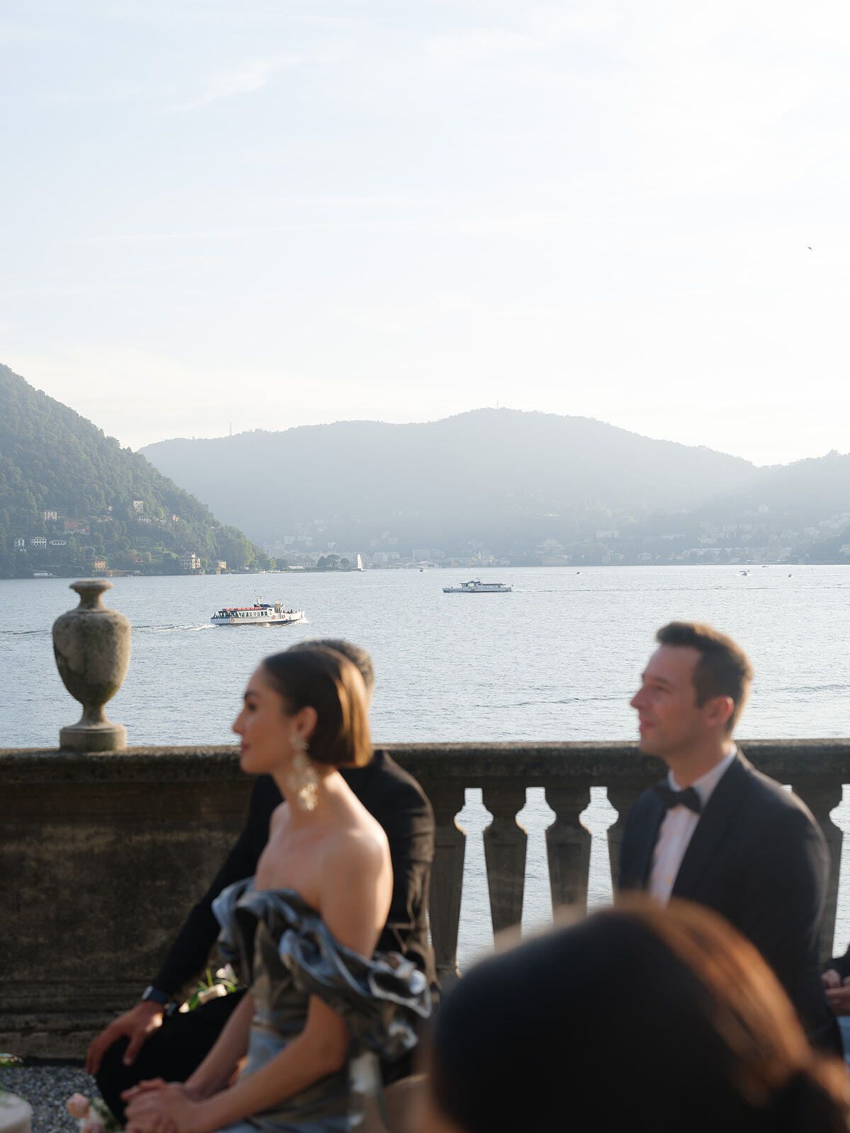 Invités assis lors de la cérémonie sur la terrasse du lac