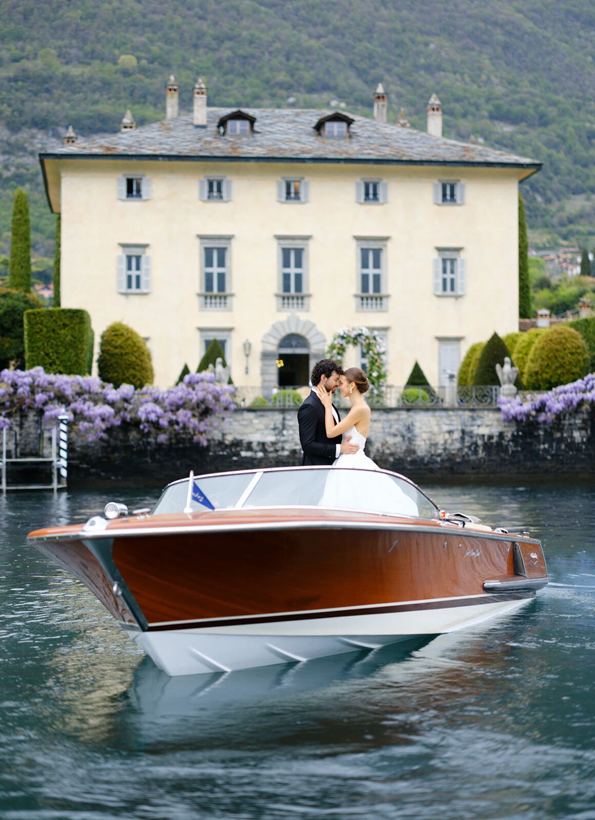 Brautpaar auf einem Riva-Boot vor der Villa Balbiano