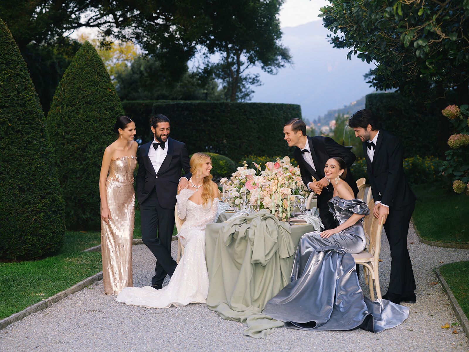 Guests in gowns around a reception table in the gardens of Villa Pizzo
