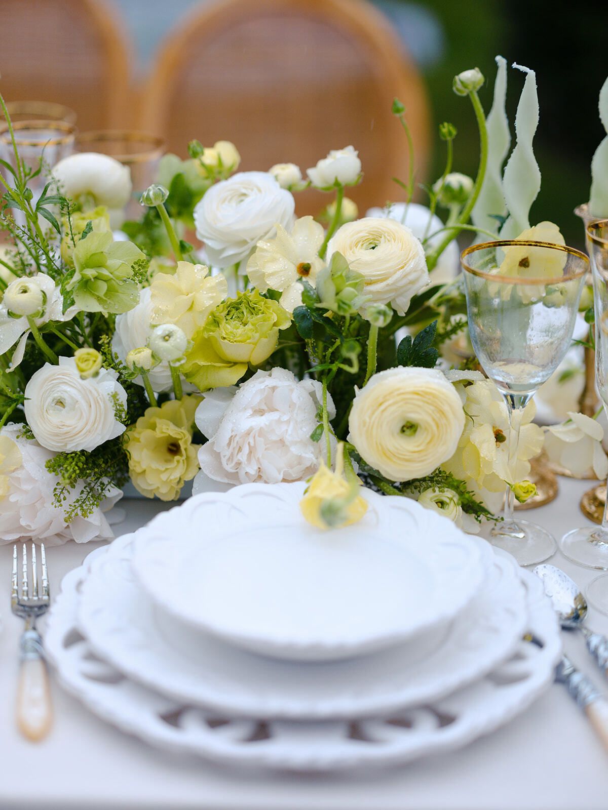 Weiße und gelbe Rosen auf einer Hochzeitstafel